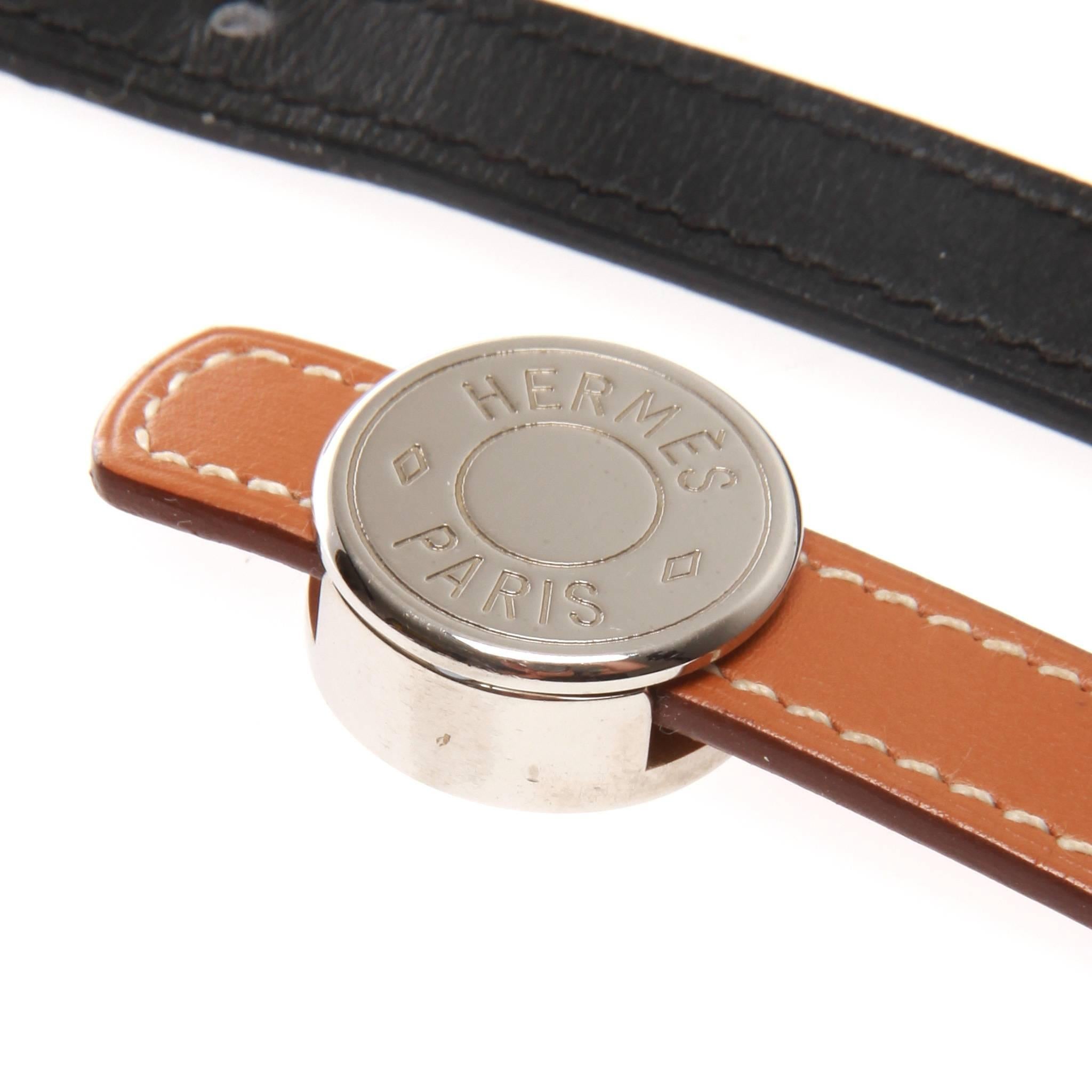 Hermes leather bracelet featuring a single interchangeable strap with silver sliding disk fastening mechanism. Disk hardware is engraved with 'Hermes Paris'.

Date stamped L in square - 2008 

Adjustable with 3 punched holes - 6.25