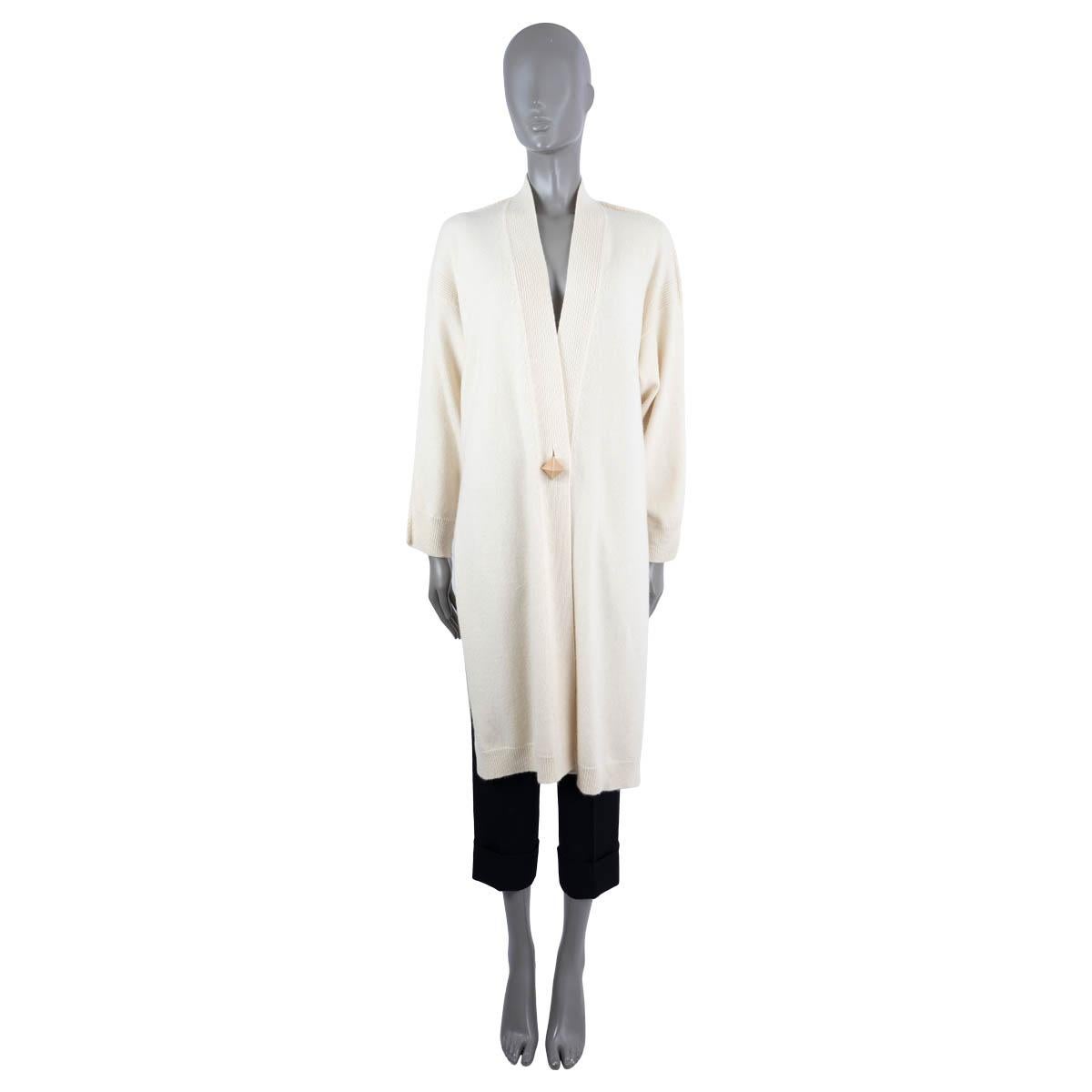 100% authentic Hermès long knit coat in ivory cashmere (100%). Features a rib-knit V-neck collar, hem and cuffs. Closes with a leather covered pyramid stud button. Unlined. Has been worn and is in excellent condition.

Measurements
Tag