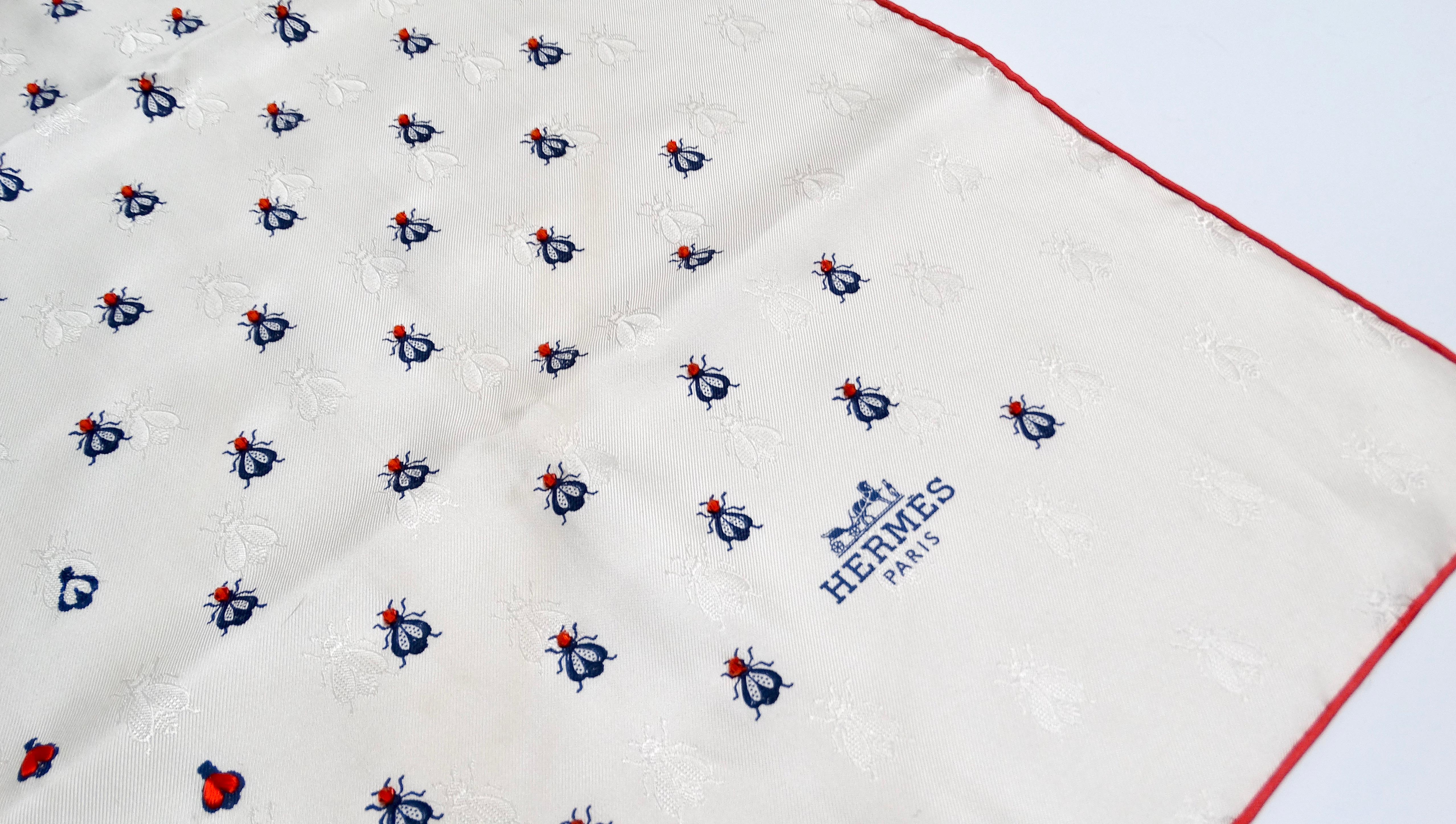 The Hermes Ivory & Ruby Toned Beaded Insect Silk Scarf is a stunning piece that showcases the brand’s exceptional craftsmanship and creativity. This 100% silk scarf features intricate prints and embroideries of delicate insects in dark blue and
