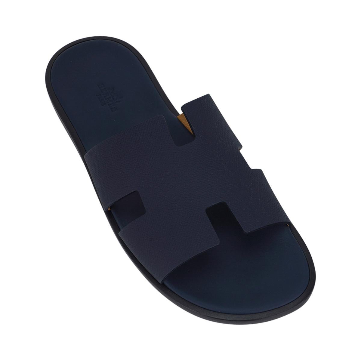 Mightychic offers a pair of Hermes Men's Izmir sandal featured in Marine - a deep navy blue.
The iconic H cutout over the top of the foot in sublime calfskin leather.
Sophisticated colour in a silhouette that works for every wardrobe.
Wood heel with
