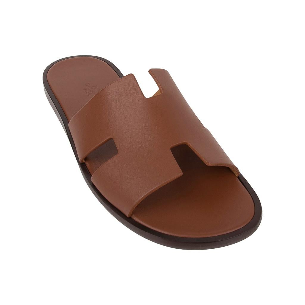Guaranteed authentic Hermes Men's Izmir sandal features classic Gold.
The iconic H cutout over the top of the foot in sublime calfskin leather.
Sophisticated colours in a silhouette that works for every wardrobe.
Insole is Gold leather. 
Wood heel