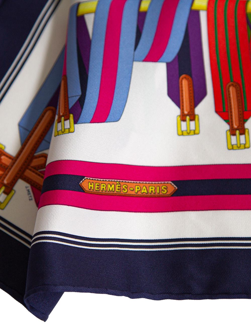 Crafted in France from the finest silk, this pre-owned scarf by Hermès was designed in 1985 by Joachim Metz. The multi-coloured 80s style scarf features a striped belt and buckle pattern with a striped border. This versatile piece would look great