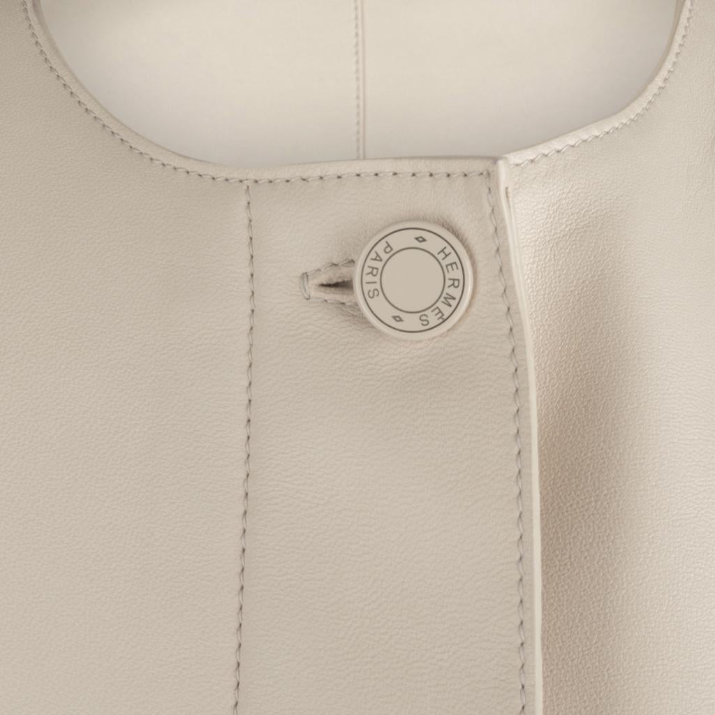Guaranteed authentic Hermes Cream lambskin leather jacket features three pockets with black leather piping. 
Hidden buttons with the top enamel Clou De Selle button in Cream.
Simple round neck and clean cut creates a timeless beauty.
The upcoming