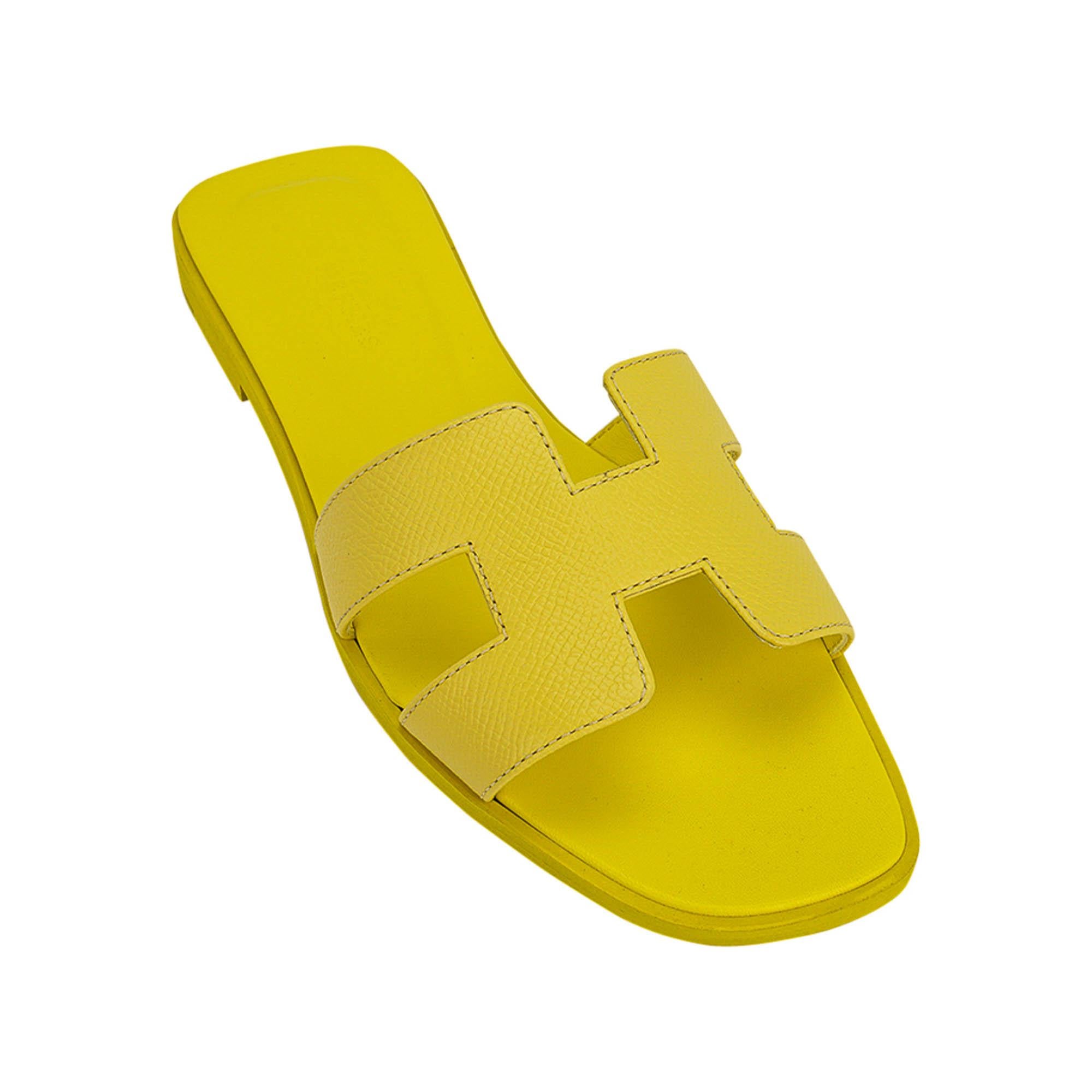 Mightychic offers a pair of Hermes Oran sandal featured in Jaune Pollen.
This pretty yellow Hermes Oran flat slide sandal is featured in Epsom leather.
The iconic H cutout over the top of the foot.
Matching embossed calfskin insole.
Wood heel with
