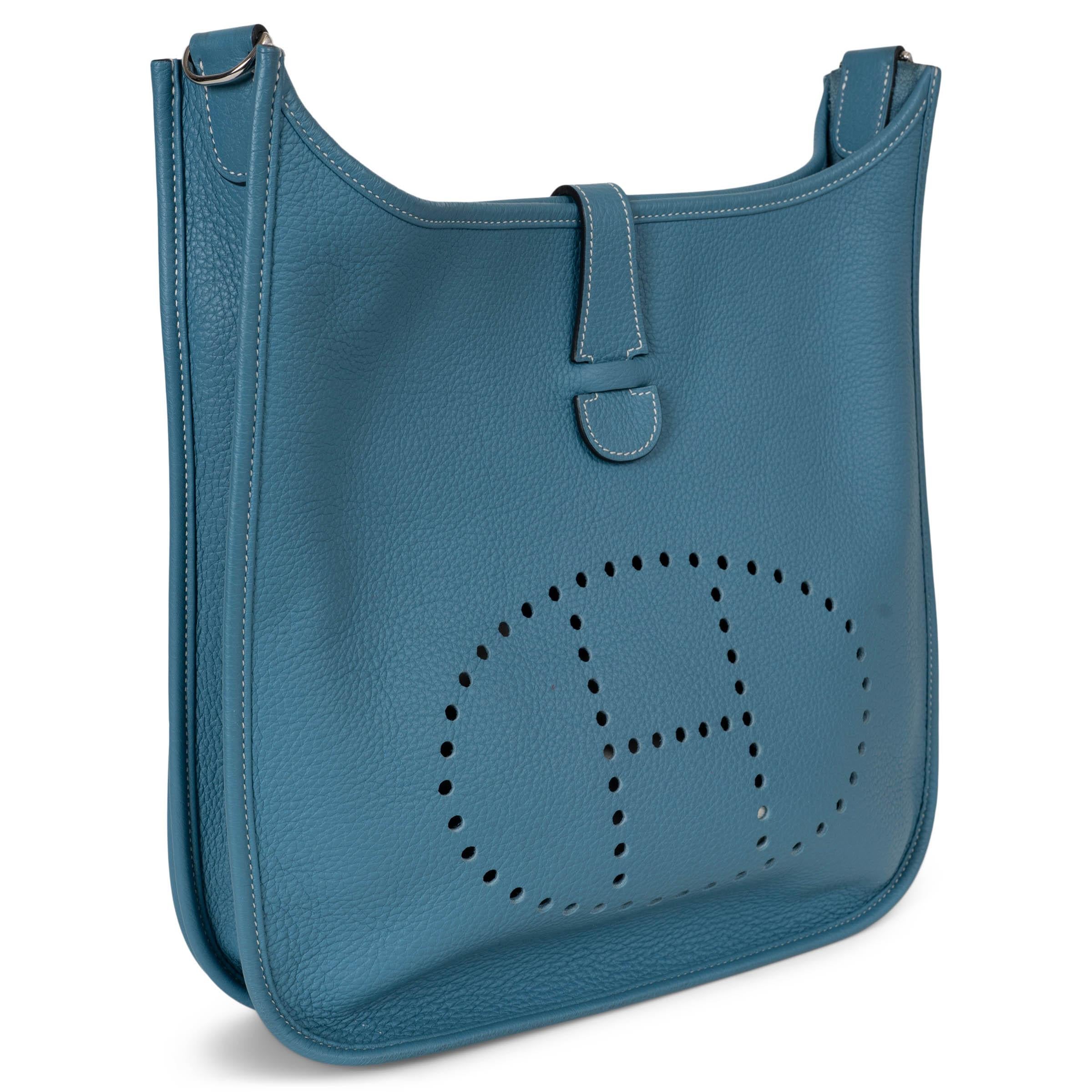 Ce sac à bandoulière Evelyne III 33, 100% authentique, est réalisé en cuir Jean Clémence bleu avec des surpiqûres blanches contrastantes et des ferrures en palladium. Il présente le motif 
