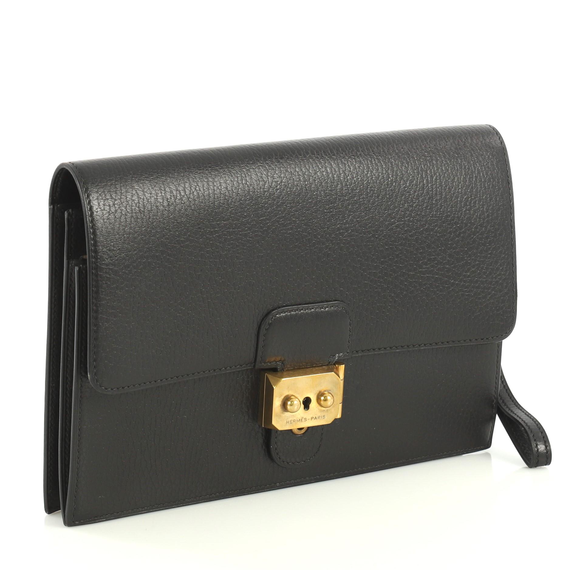 This Hermes Jet Clutch Ardennes, crafted from Noir black Ardennes leather, features a leather wrist strap, zip pocket under flap and brass hardware. Its clasp closure opens to a Noir black Ardennes leather interior. Date stamp reads: Z Circle