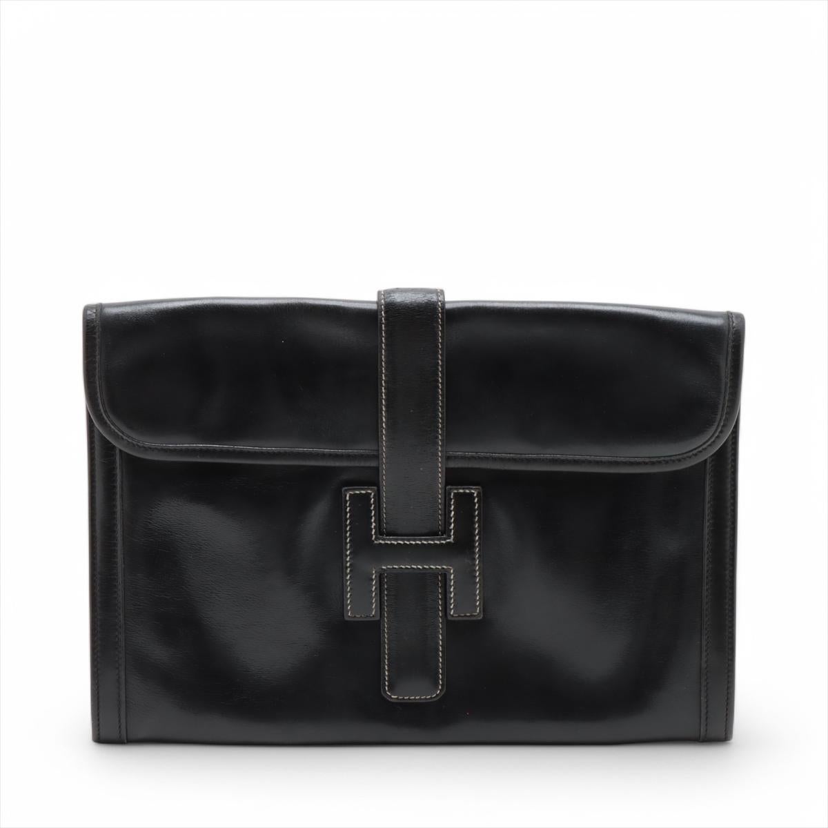 Die Hermès Jige PM Clutch aus schwarzem Box Calf Leder ist ein raffiniertes und zeitloses Accessoire, das die Hingabe der Marke für schlichte Eleganz verdeutlicht. Die Clutch ist aus glattem, poliertem Kalbsleder mit dezentem Glanz gefertigt und