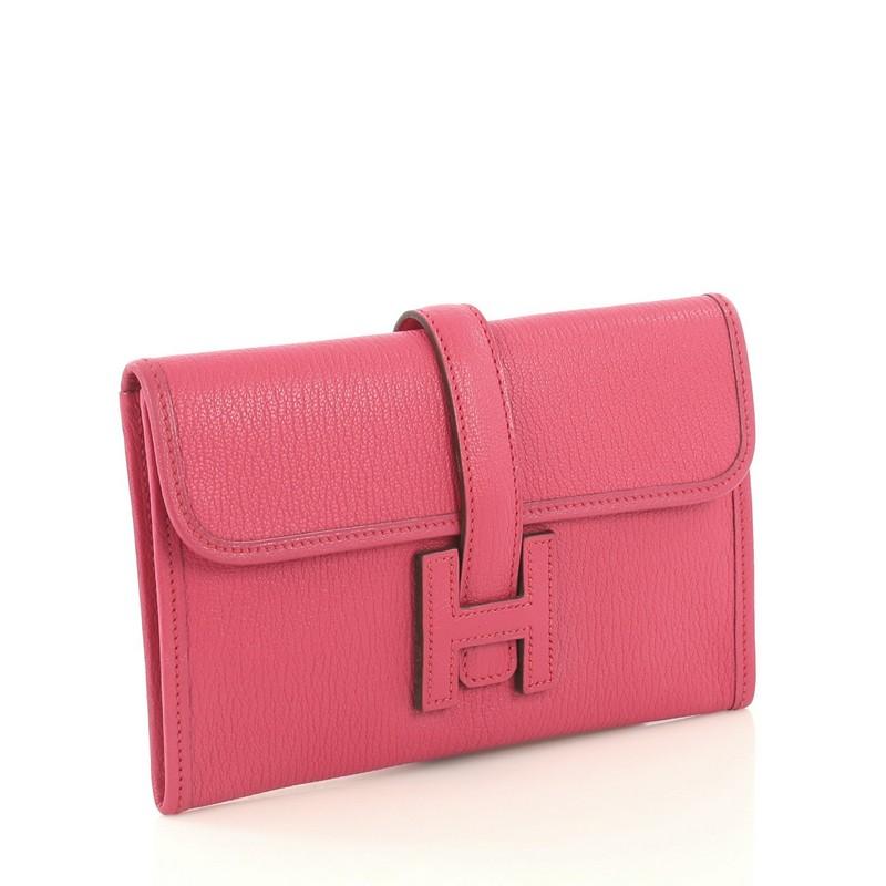 This Hermes Jige Clutch Chevre Mysore 20, crafted in Rose Shocking pink Chevre leather, features a cross-over flap and strap that tucks under the logo H. It opens to a Rose Shocking pink Agneau leather interior. Date stamp reads: J Square (2006).