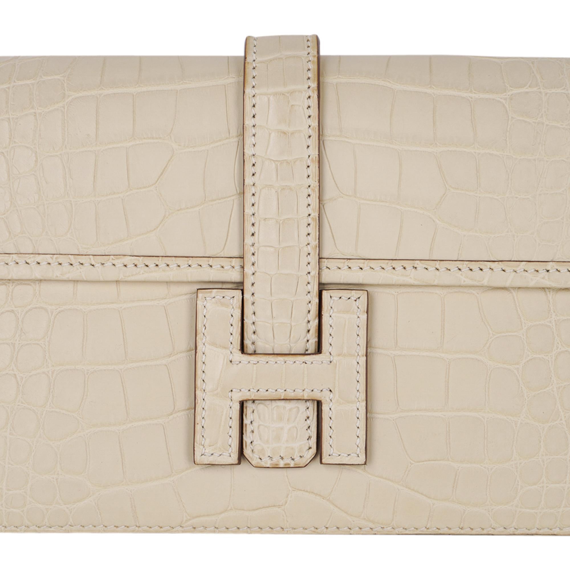 Mightychic offers a guaranteed authentic  Hermes Jige Duo Wallet featured in neutral perfection Vanille Matte Alligator. 
This stunning Hermes Duo wallet also doubles as a clutch.
Signature H with strap for closure.
Two interior slot pockets.