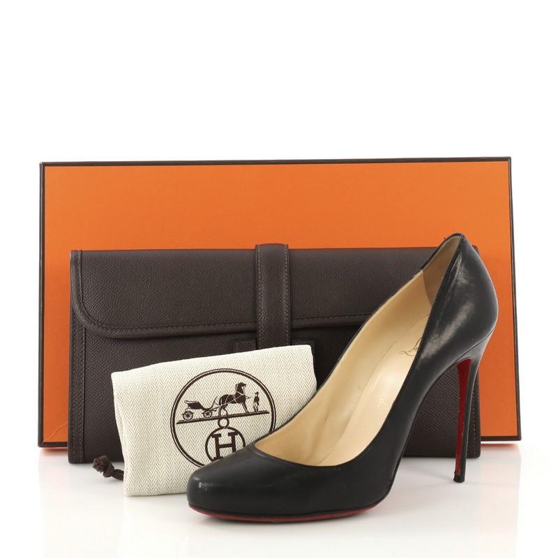 This Hermes Jige Elan Clutch Epsom 29, crafted in Chocolate brown Epsom leather, features a cross-over flap and strap that tucks under the logo H. It opens to a Chocolate brown Chevre leather interior. Date stamp reads: M Square (2009). **Note: Shoe