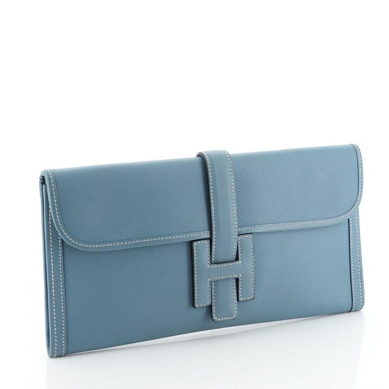 This Hermes Jige Elan Clutch Epsom 29, crafted in Bleu Jean blue Epsom leather, features a cross-over flap and strap that tucks under the logo H. It opens to a Bleu Jean blue Agneau leather interior. Date stamp reads: J Square (2006). 

Estimated