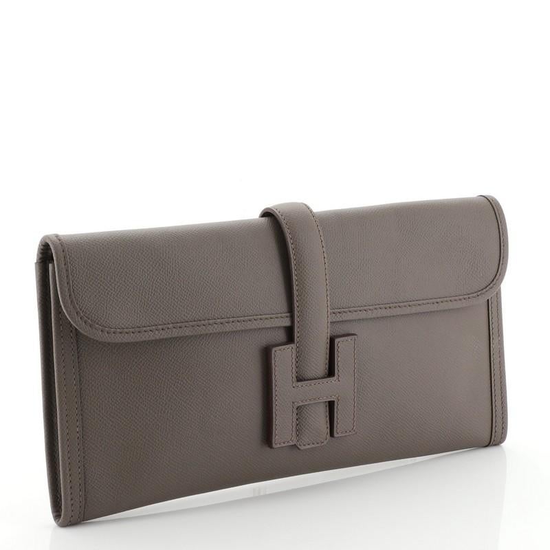 This Hermes Jige Elan Clutch Epsom 29, crafted in Etain neutral Epsom leather, features a cross-over flap and strap that tucks under the logo H. It opens to an Etain neutral Chevre leather interior. Date stamp reads: Q Square (2013). 
Estimated
