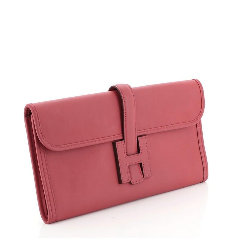 This Hermes Jige Elan Clutch Swift 29, crafted in Vermillion red Swift leather, features a cross-over flap and strap that tucks under the logo “H”. It opens to a Vermillion red Swift leather interior. Date stamp reads: T (2015). 

Estimated Retail