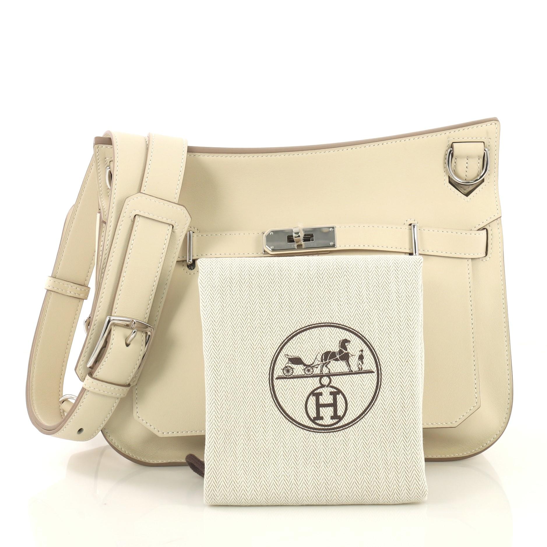 This Hermes Jypsiere Handbag Swift 28, crafted in Craie off white Swift leather, features a long adjustable strap and palladium hardware. Its turn-lock clasp closure opens to a Craie off white Swift leather interior with slip and zip pockets. Date