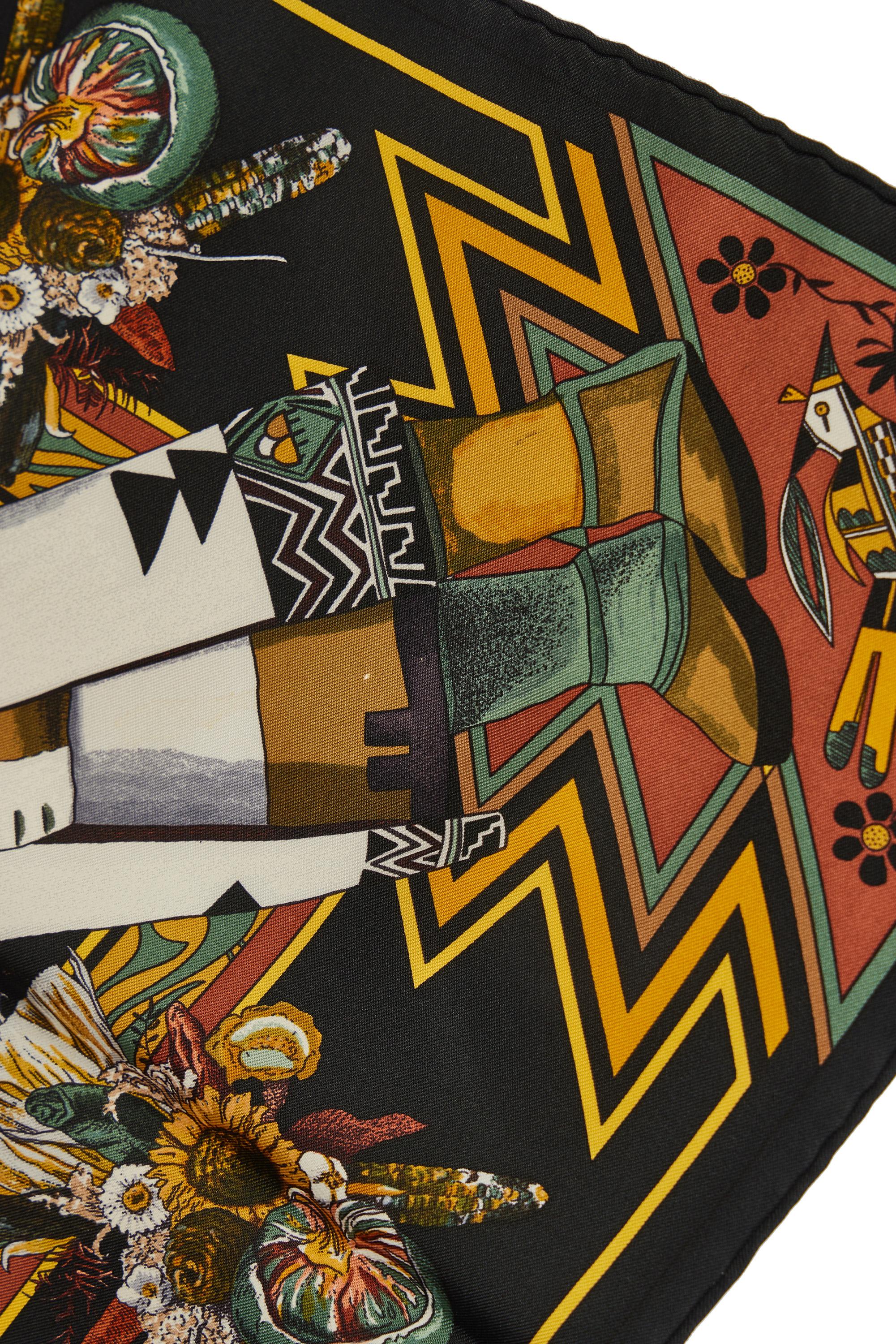 Écharpe en soie imprimée Kachinas Hermès par l'artiste Kermit Oliver. Bords roulés à la main. Coloris noir et marron. 