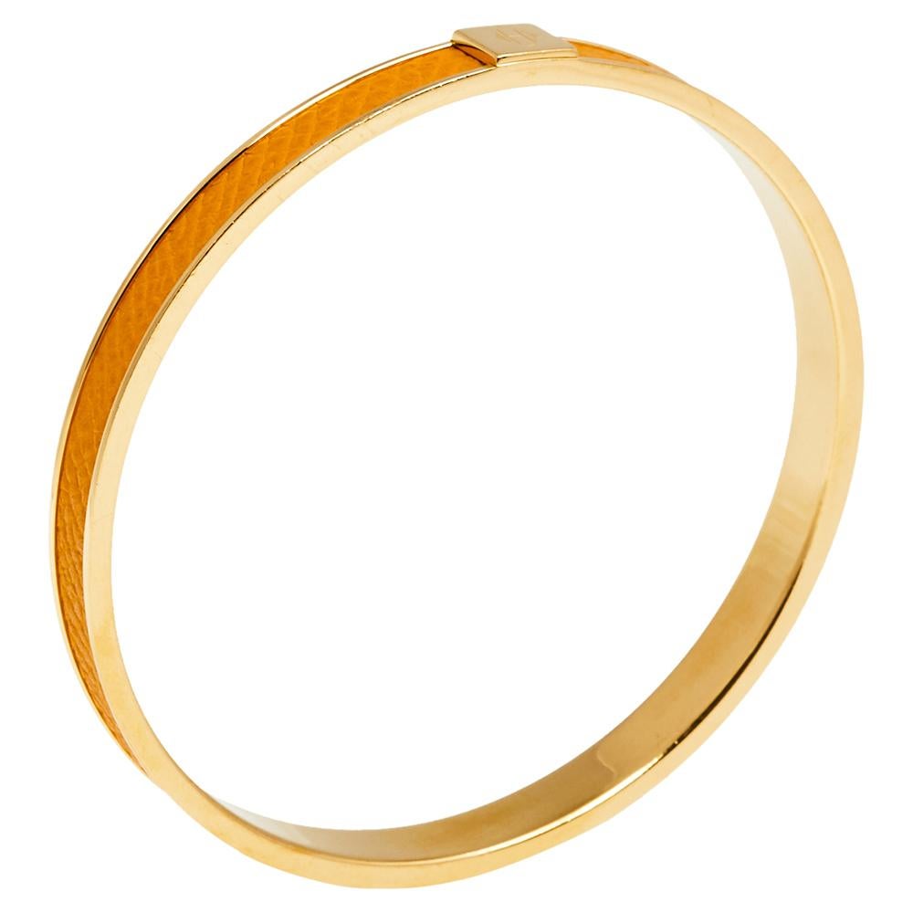 Simple yet sophisticated, this bracelet from the house of Hermés features an orange-hued Kawaii leather & gold-plated metal body and is topped with the 'Hermés' logo on it. Wear it by stacking it with similar bracelets.