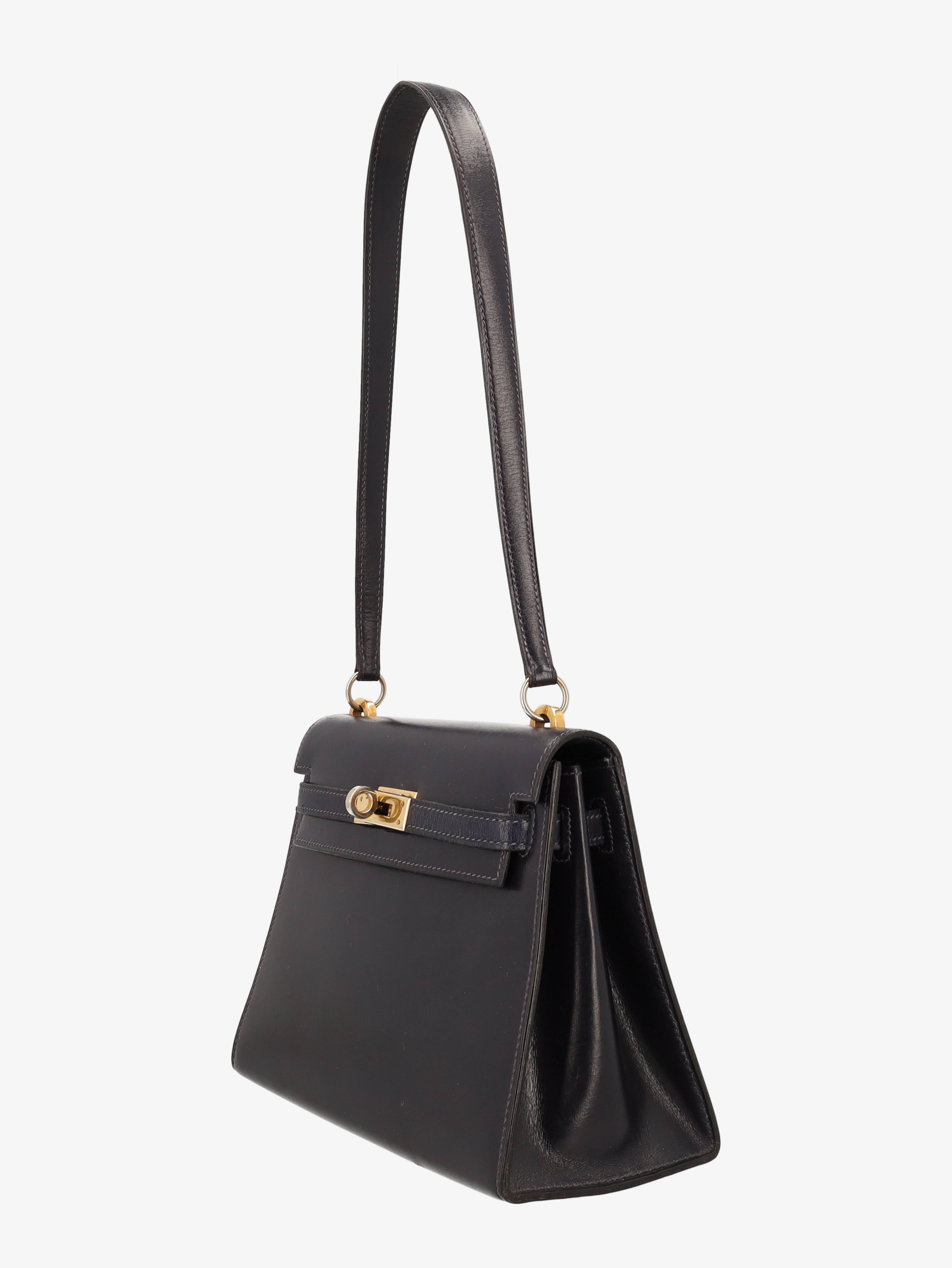 Rare Hermès Kelly 20 cm bag in dark blue leather, gold metal hardware, distinctive simple leather shoulder strap to be carried by hand, on the shoulder or over the shoulder. Flap closure, interior leather lining with a small patch pocket. C