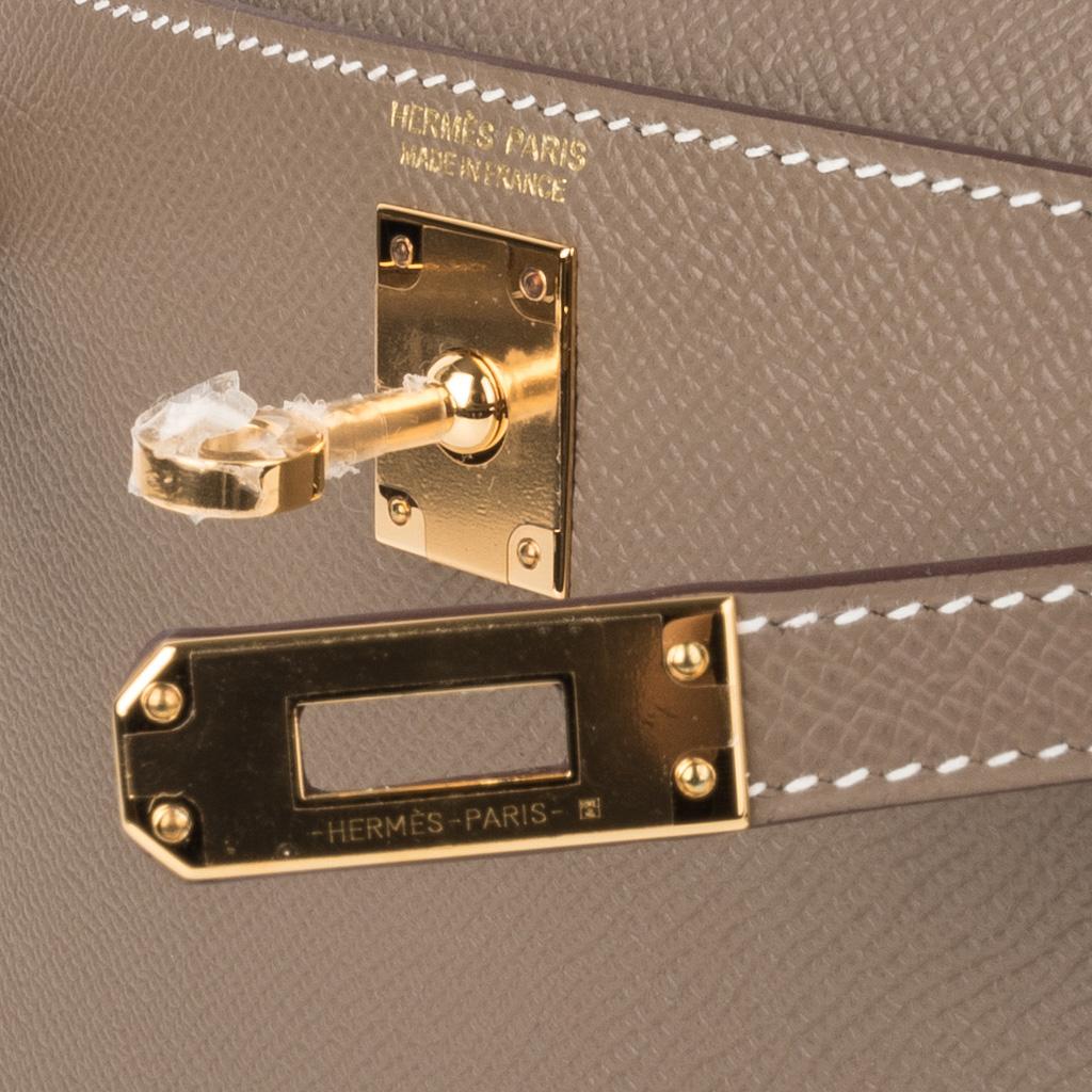 Guaranteed authentic Hermes Kelly 20 Sellier Mini bag.
Coveted neutral Etoupe Epsom leather with gold hardware.
Carry by hand, shoulder or cross body.
Divine size for day to evening. 
Comes with signature Hermes box, shoulder strap, and sleeper.
NEW