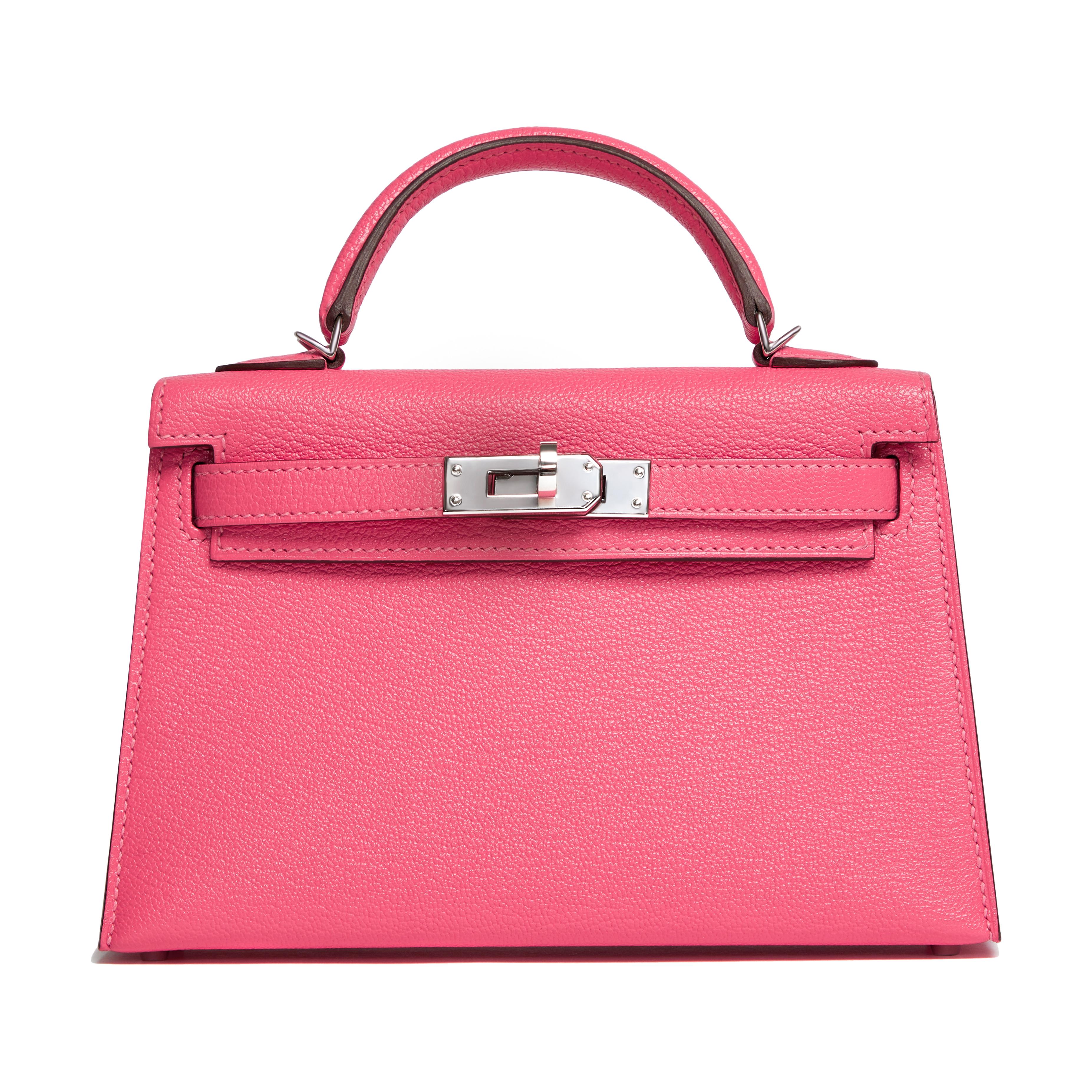 This stunning Hermès Kelly 20cm bag is featured in Rose Lipstick color and made in Chevre Mysore leather. It features single rolled top handle, front flap with turn lock, and palladium hardware. This Kelly bag opens to a pink leather interior with a