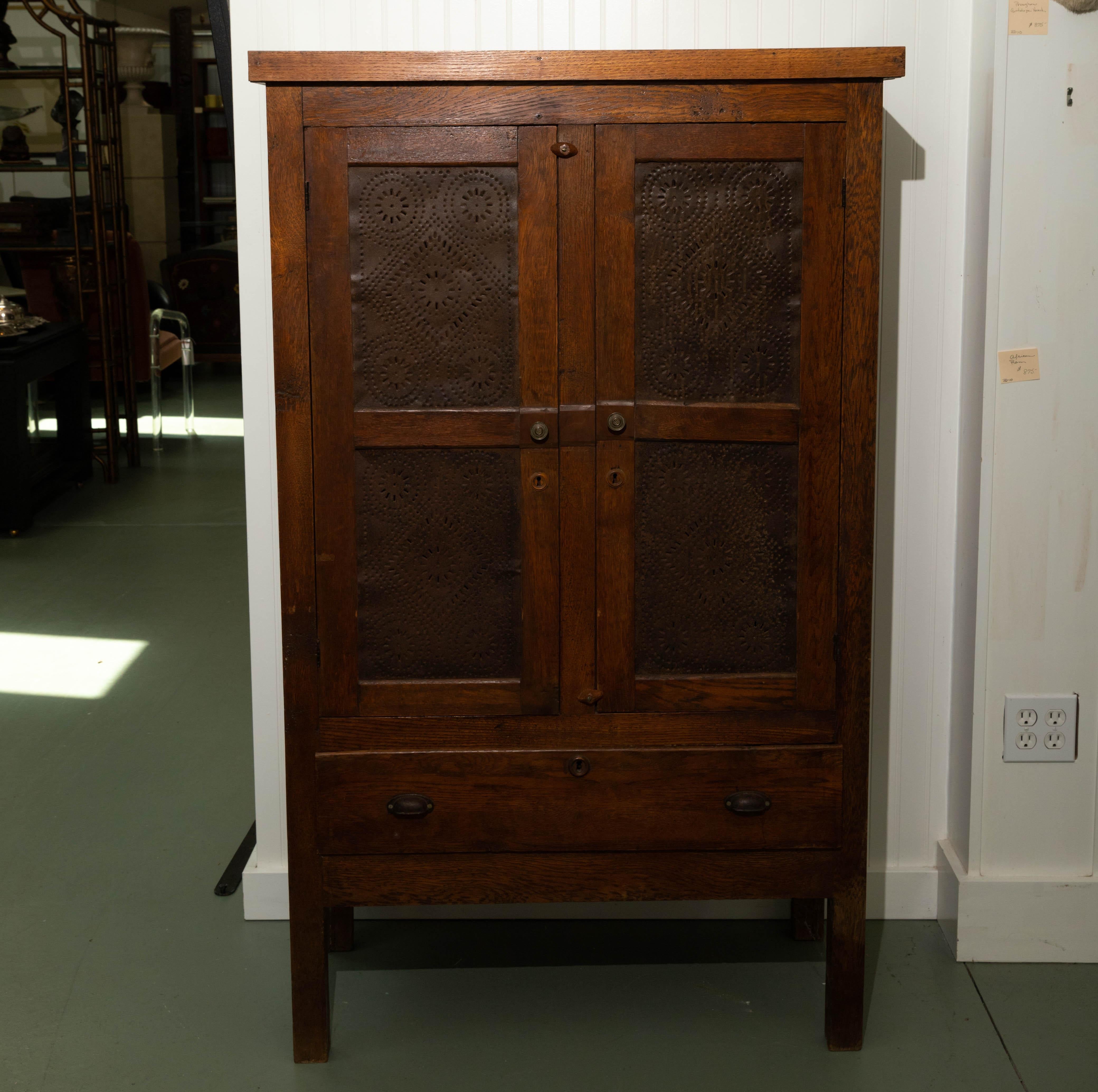 Early 19th century pie safe. Two-door over one drawer, interior two shelves, perforated tin panel doors. Five recessed panels on each side.
Original patina.