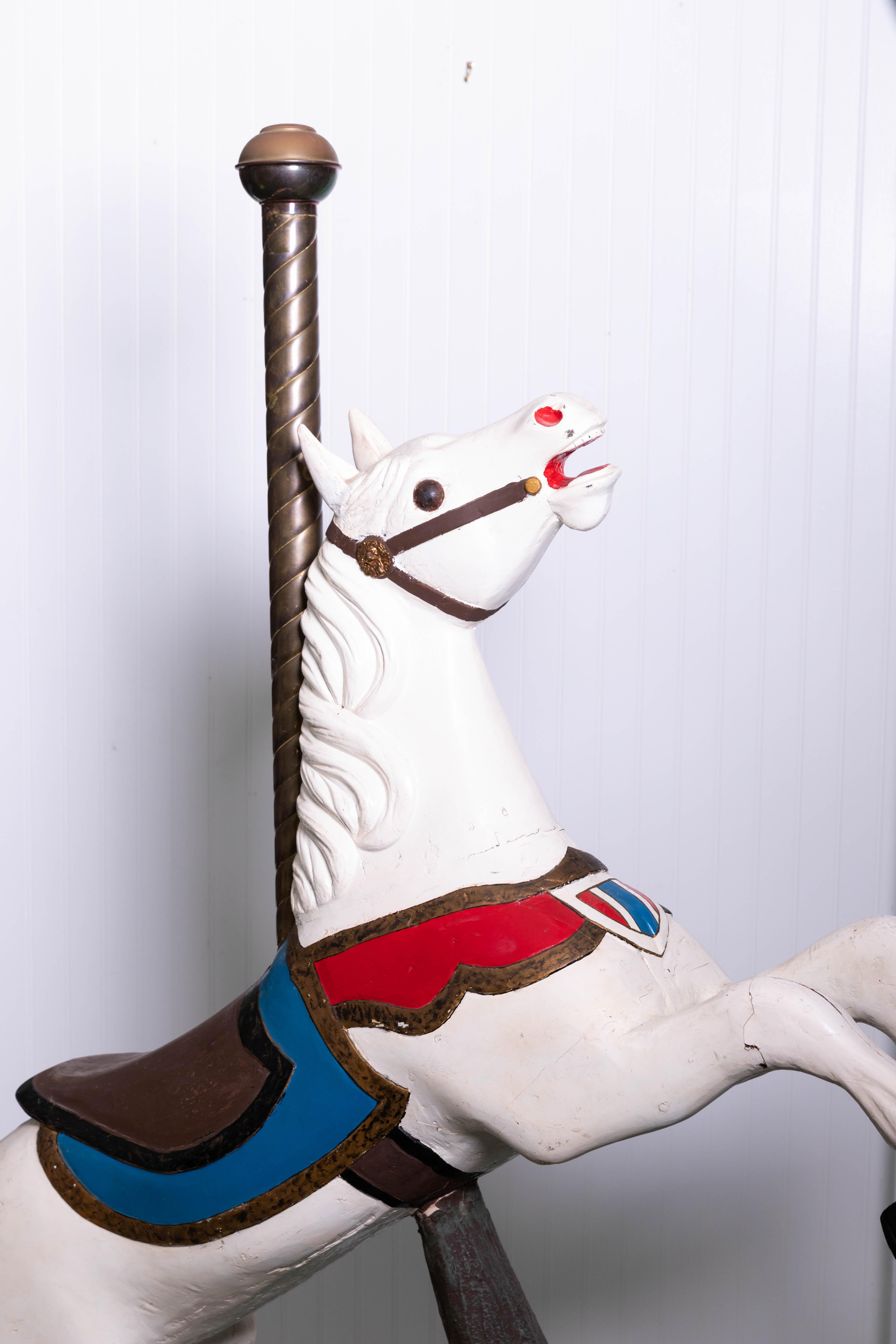 Wooden carousel horse in fixed position. Original gresso over wooden base resembling tree trunk. Horse has been repained while brass pole is an early addition with ears that were replaced.