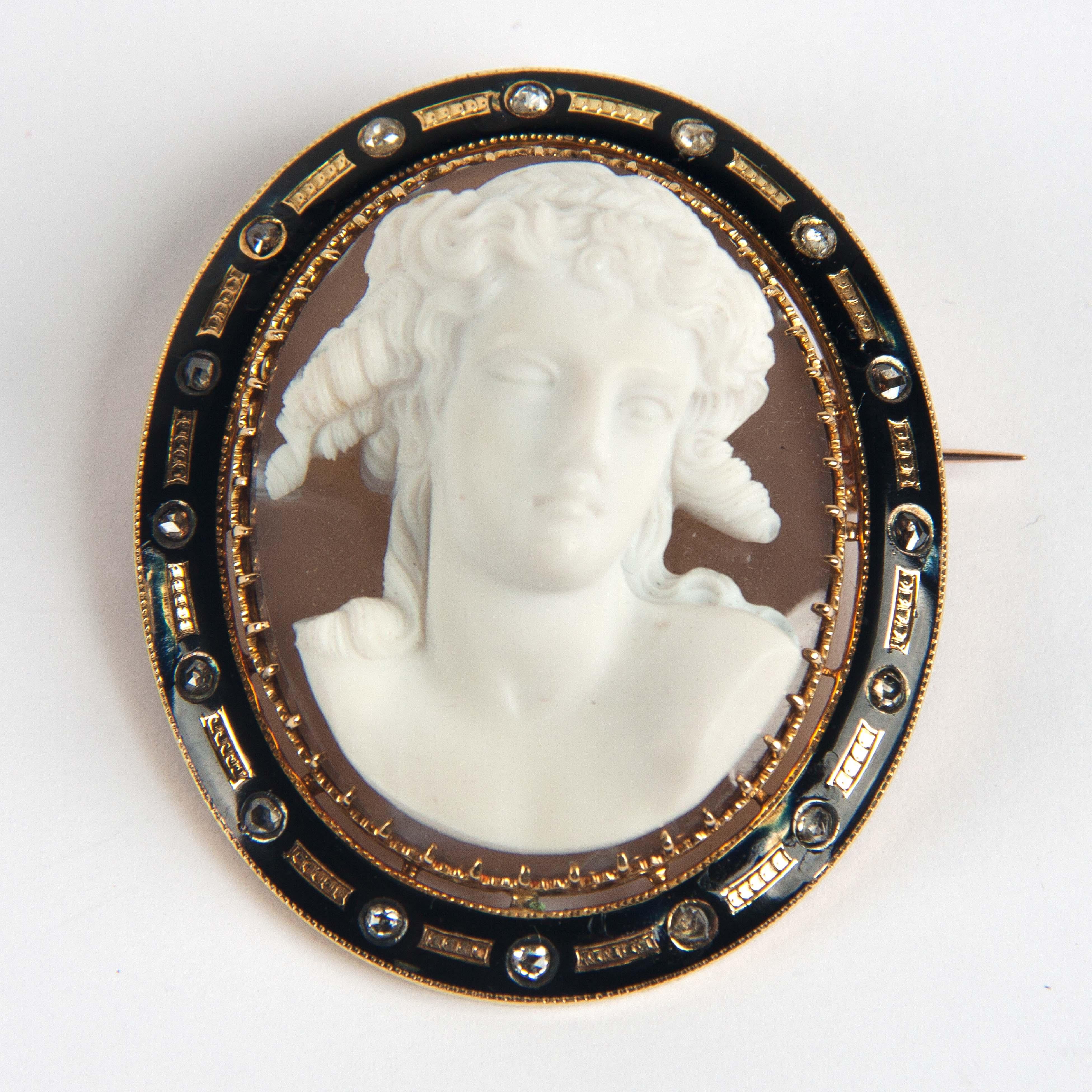 Bijou en or du 19ème siècle, dans une fine tête sculptée en porcelaine de Sèvres sur une plaque d'agate.
Le cadre est en email de Limoges avec des diamants.
 