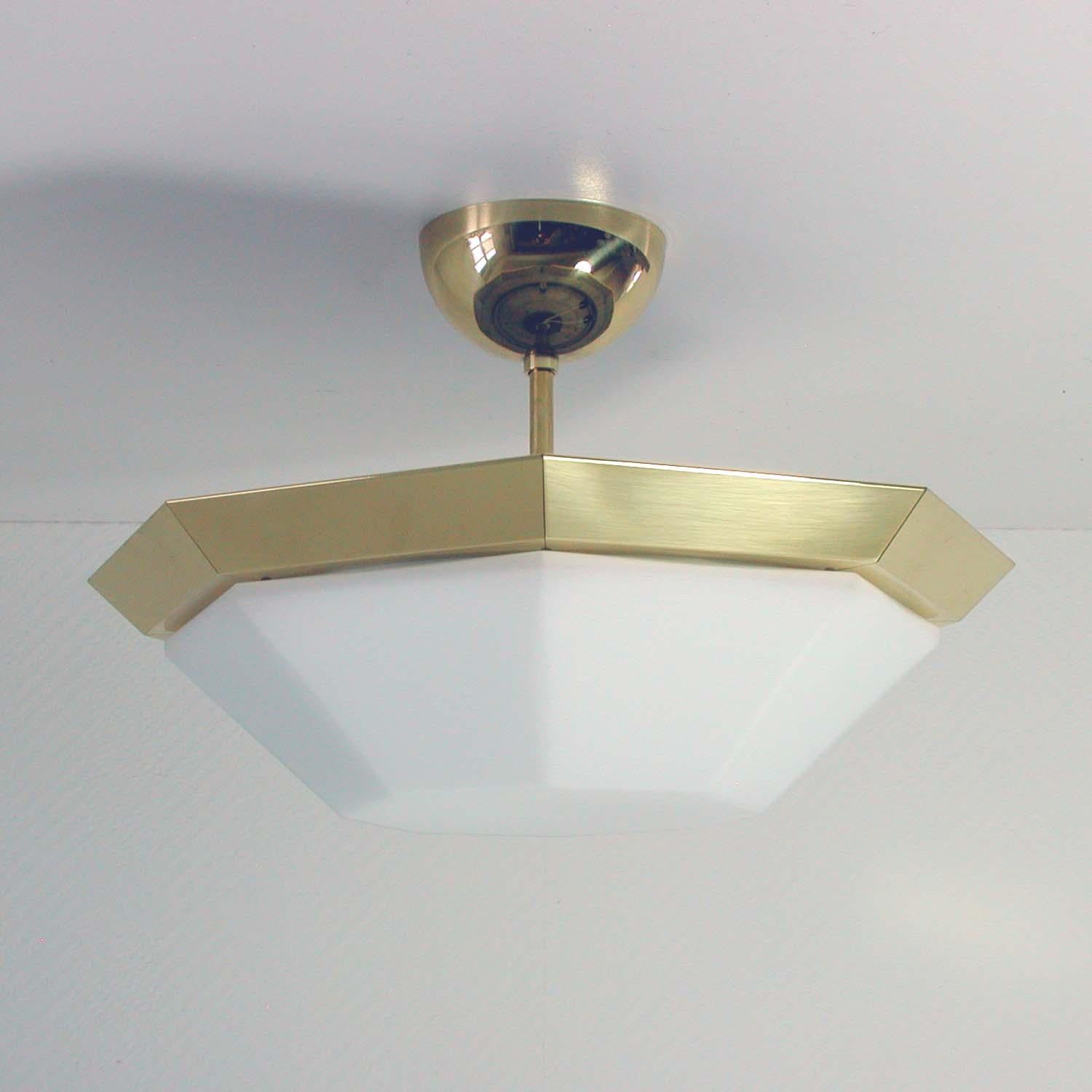 This vintage midcentury lamp was manufactured by Limburg in the 1960s. It is model number 7028. It has got an octagonal brass frame and a milk glass lamp shade.

The lamp can be used as a wall light / sconce or a flush mount (either with lamp rod
