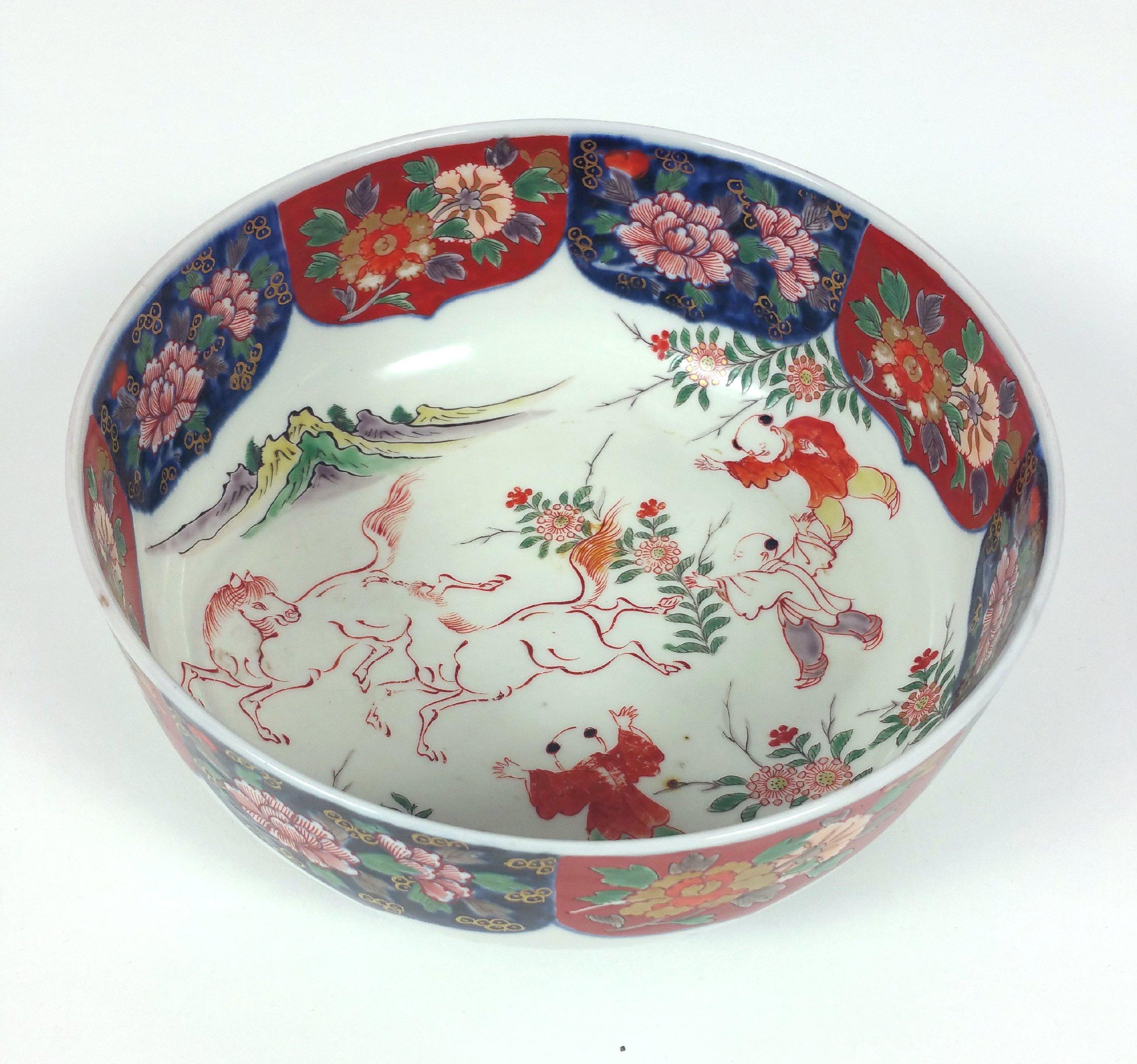 This very attractive 19th century Japanese pottery bowl painted with wild horses and boys in a mountainous landscape within a frieze painted with flowers on the inside. There are four character marks on the base with additional floral decoration on
