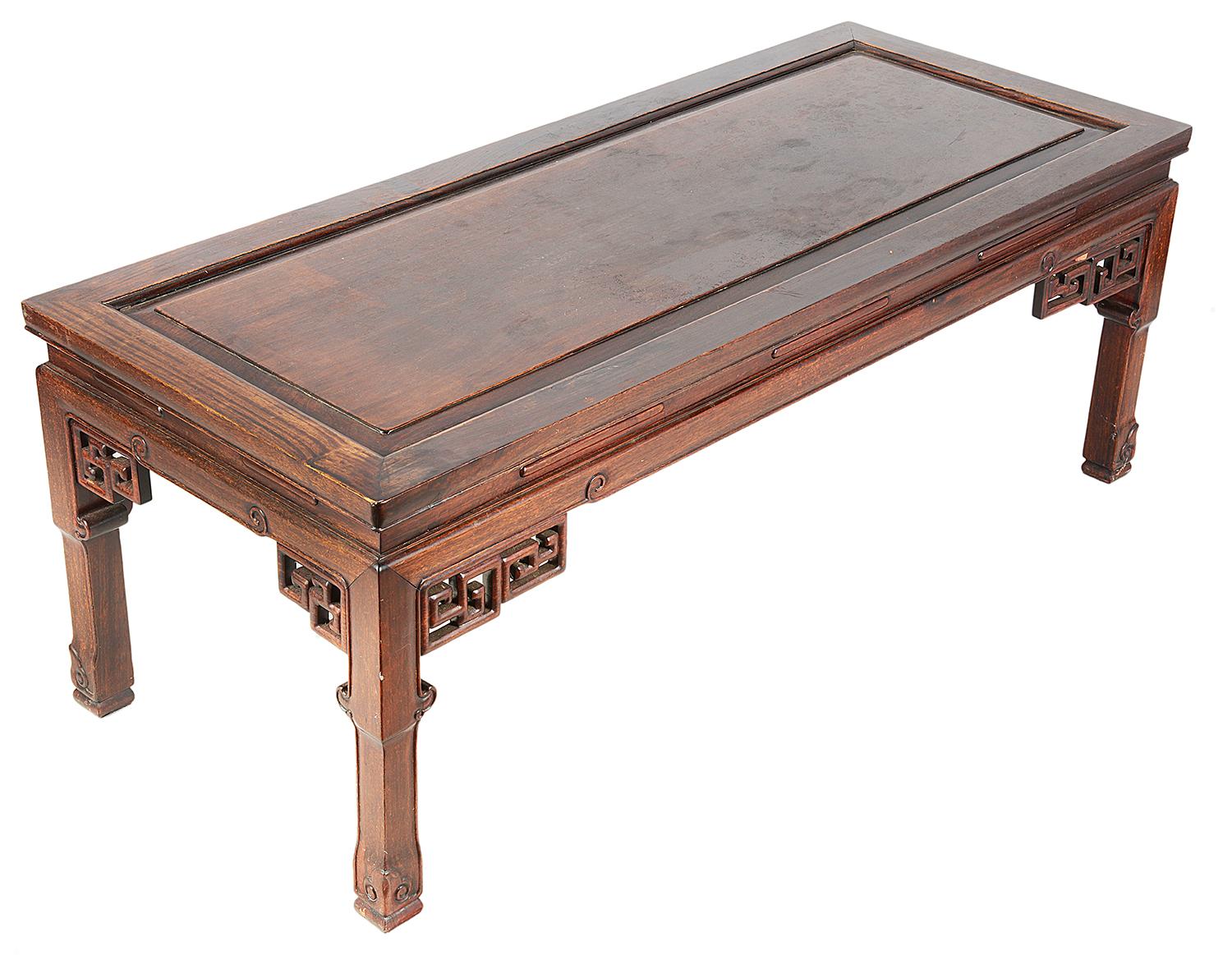 A 19th century Chinese hardwood Opium table or coffee table, having an inset panel to the top, delicate carved decoration to the frieze and brackets, raised on square section legs with leaf like decoration to the feet.