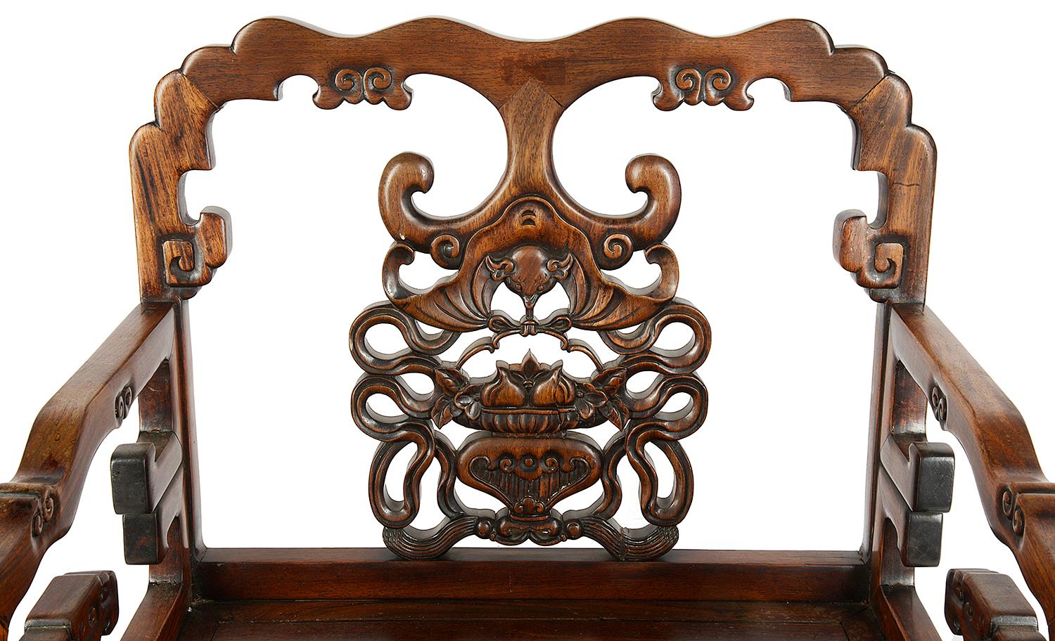 An impressive 19th century Chinese hardwood armchair, having classical carved motif decoration to the back, depicting bats, melons and foliage. Raised on square section legs and united by a stretcher between.