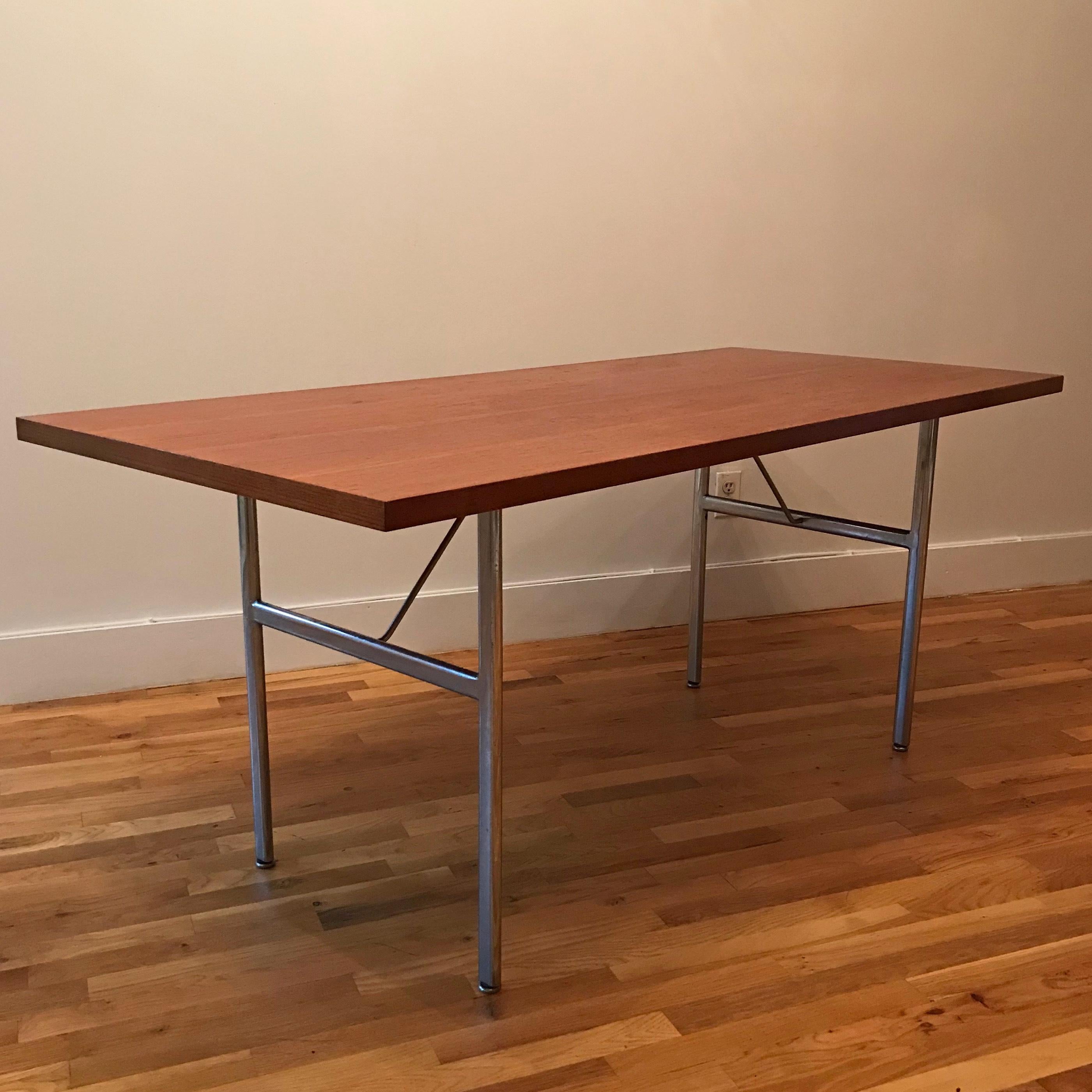 Mid-Century Modern dining table by George Nelson for Herman Miller features a steel H frame base with chestnut top.