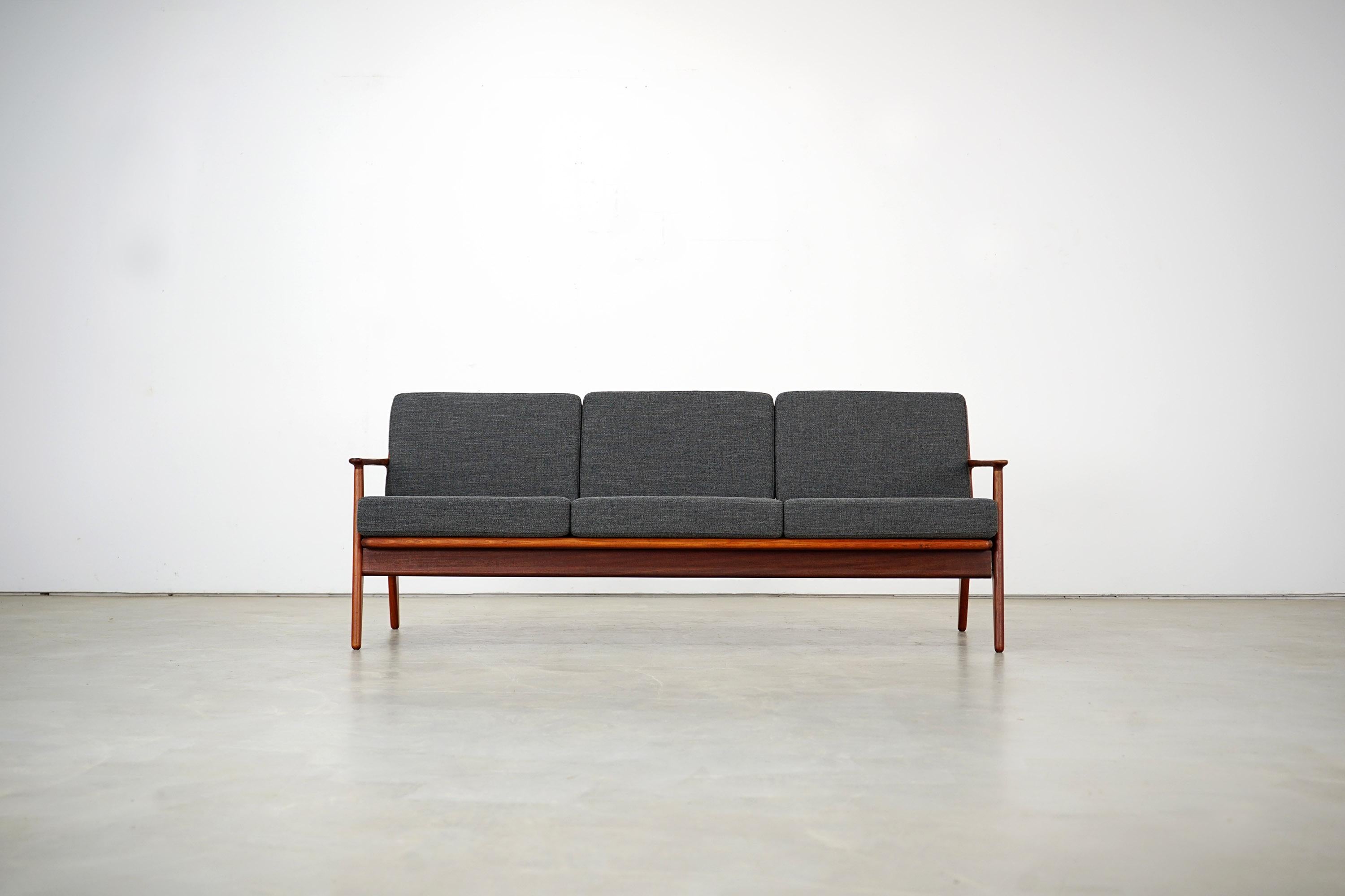 The sofa designed by Arne Vodder for Vamo Sønderborg can accommodate up to three people. It was manufactured in Denmark in the 1960s. Teak was used for the high quality workmanship. The exceptional soft-edged design is complemented by high-quality