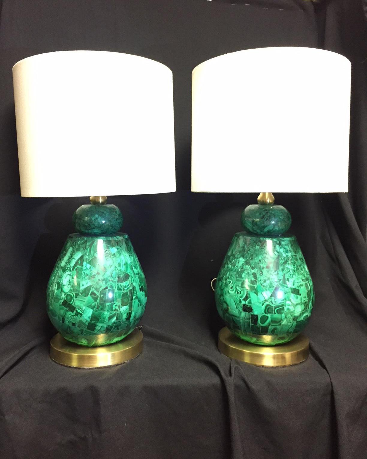 Lovely pair of brass and malachite veneered lamps with shades. 
Cylindrical white shades over malachite inlaid baluster shaped lamps on round brass base. Polished brass hardware.

Shade and finial included. Cylindrical shades recommended.
Wiring