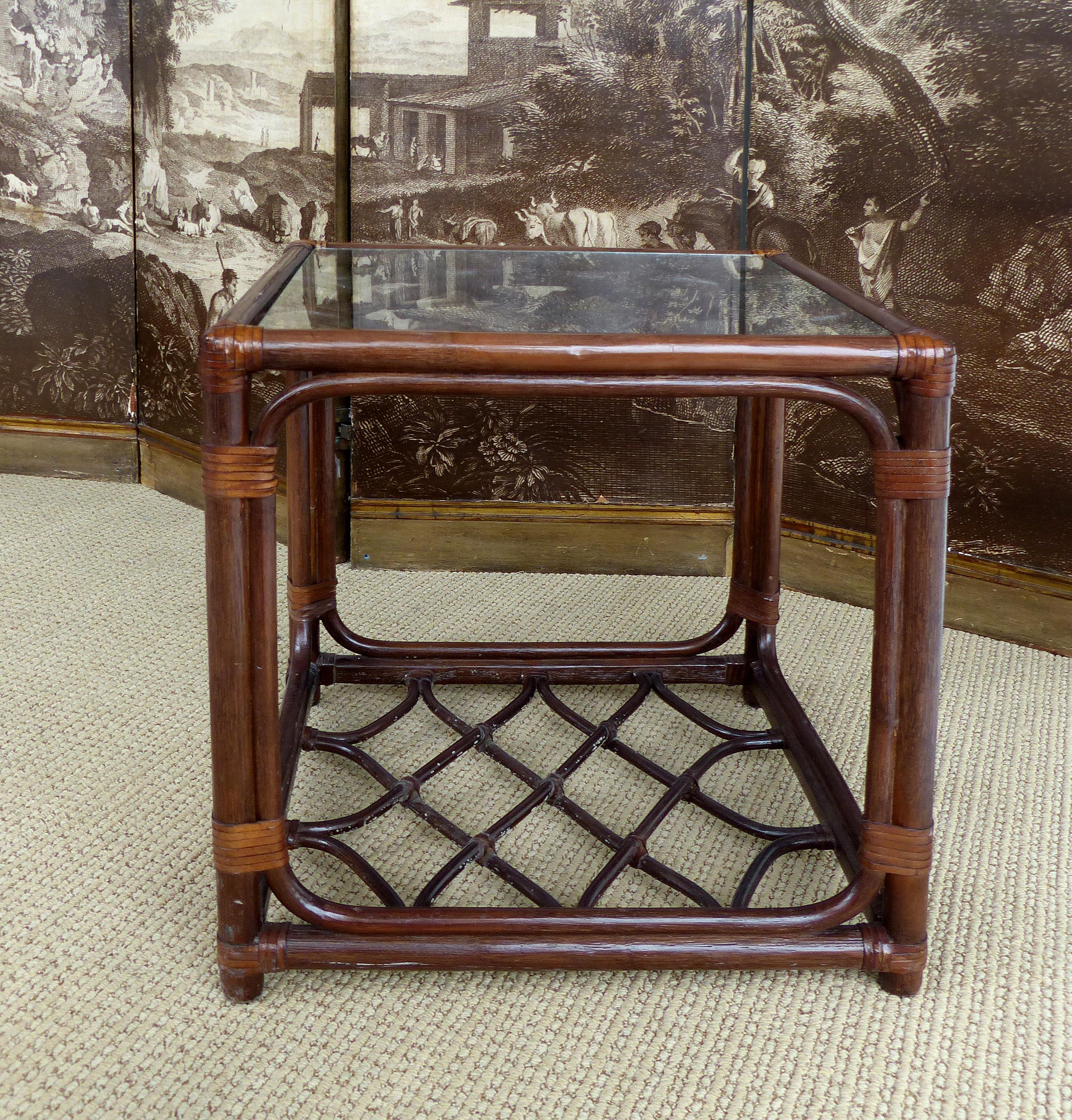 Rattan Side Table, Criss Cross Design, Leather Strapping attributed to McGuire

Offered for sale is a square rattan side table, attributed to McGuire,  with leather wrapped details and ends. The table has a recessed glass top and an additional shelf