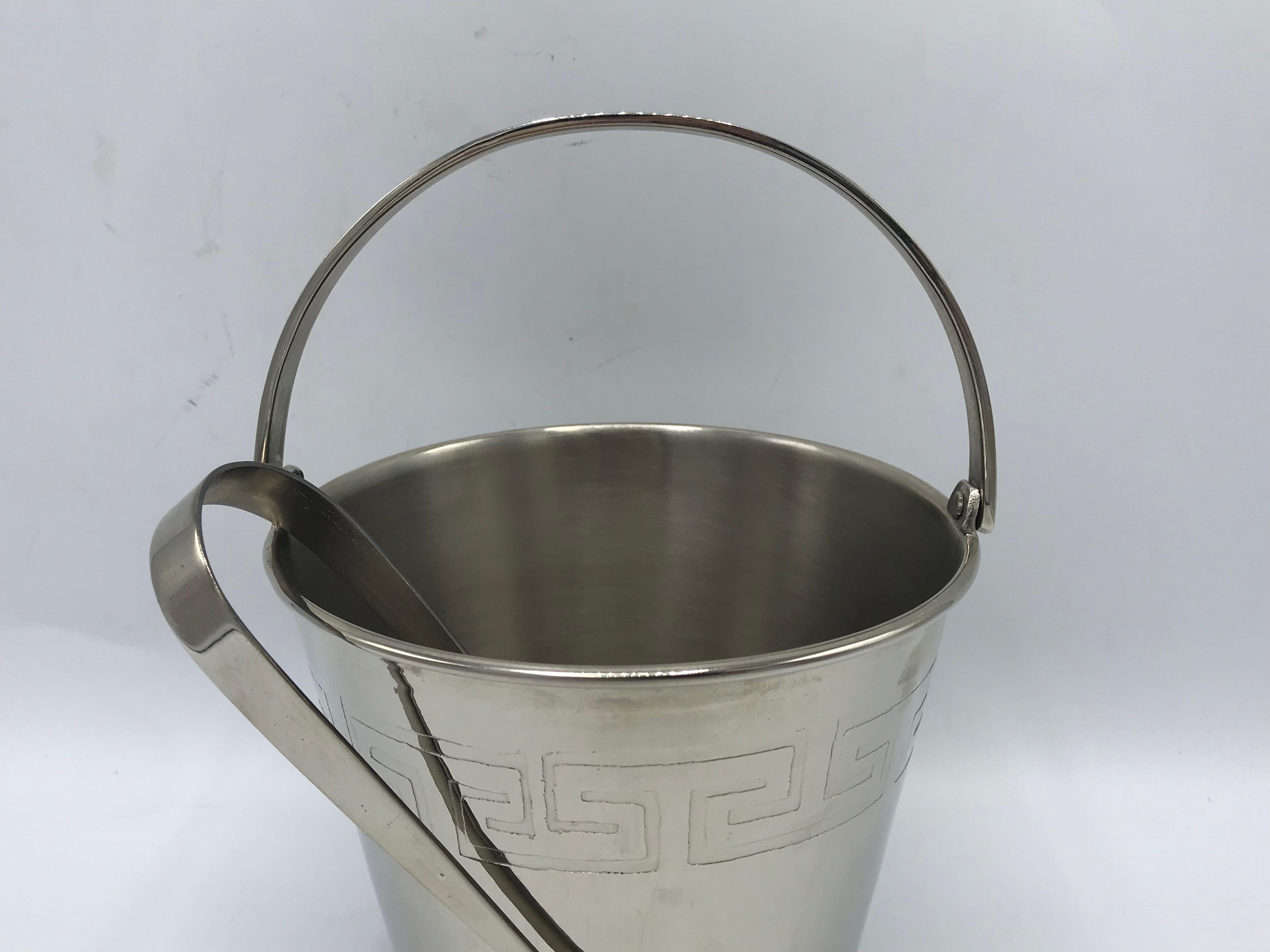 Listed is a beautiful, 1970s chrome ice bucket and tongs. The piece has a lovely stamped greek-key motif along the border of the bucket. 

From top to bottom of bucket, without handle is 5in.

Tongs: 7in high x 2in wide x 1in deep.