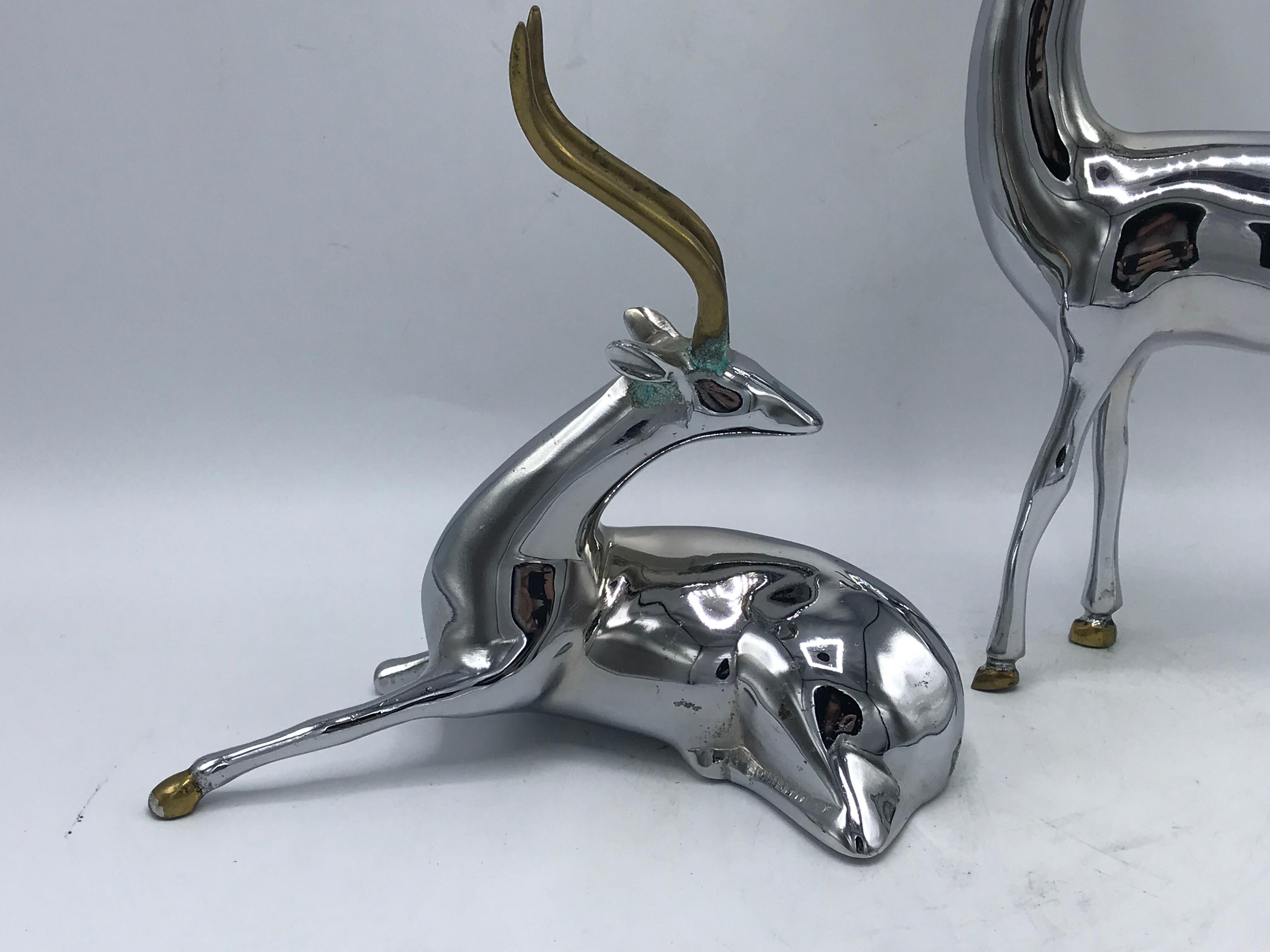 Listed is a gorgeous and rare, pair of 1960s chrome gazelle sculptures. The pair have brass horn and hoof accents. Heavy. 

Standing gazelle: 12.5in H x 7in W x 2in D
Sitting gazelle: 7.75in H x 8in W x 3.25in D.