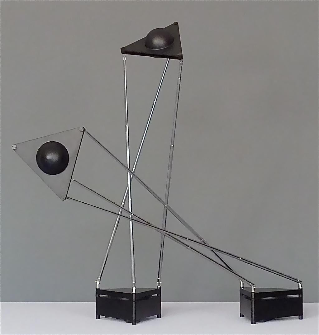 A pair of sculptural modern table lamps designed by F.A. Porsche in 1989 and manufactured by Kandido for Luci Italia. The teleskopic halogen table lamps have a casted aluminum black enameled base with an integrated oversize circular ON / OFF
