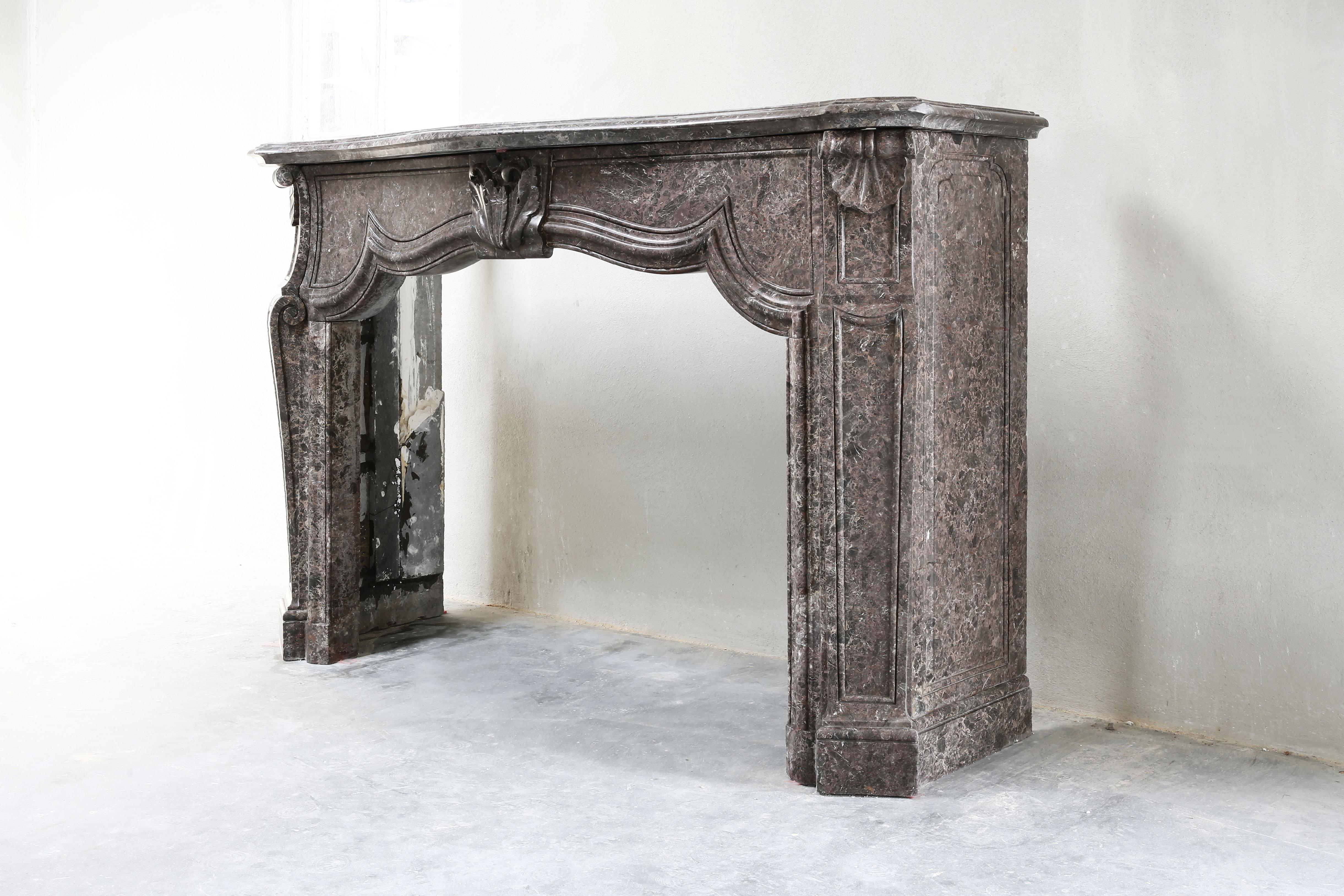 Very nice elegant and robust fireplace of marble. An antique fireplace from the 19th century from the time of Louis XV. This marble type is called Emperador, a color nuance of dark brown and beige, which is calm in structure. This antique fireplace