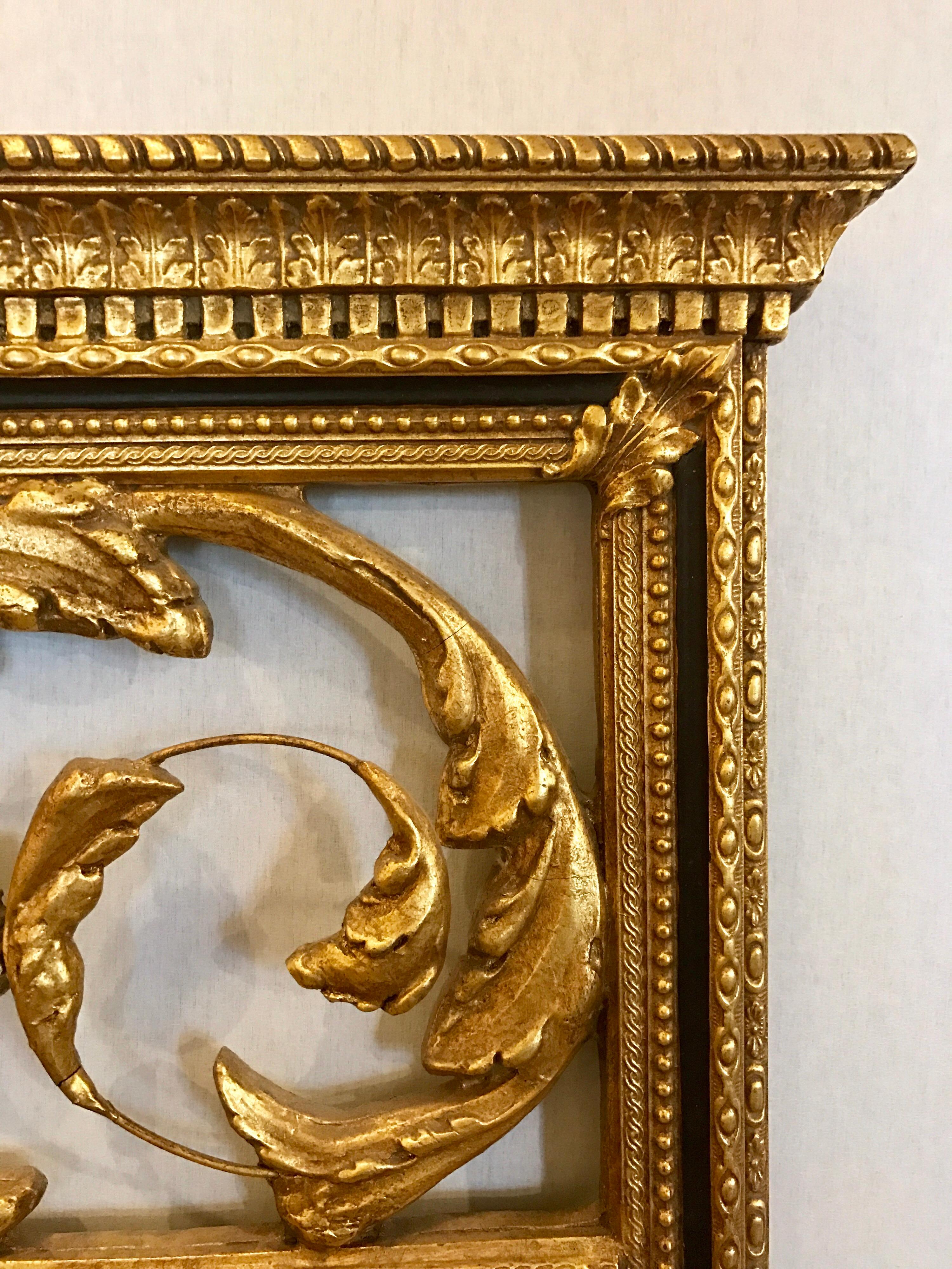 Large carved Decorative Arts Friedman Brothers gilt mirror with carvings at top.