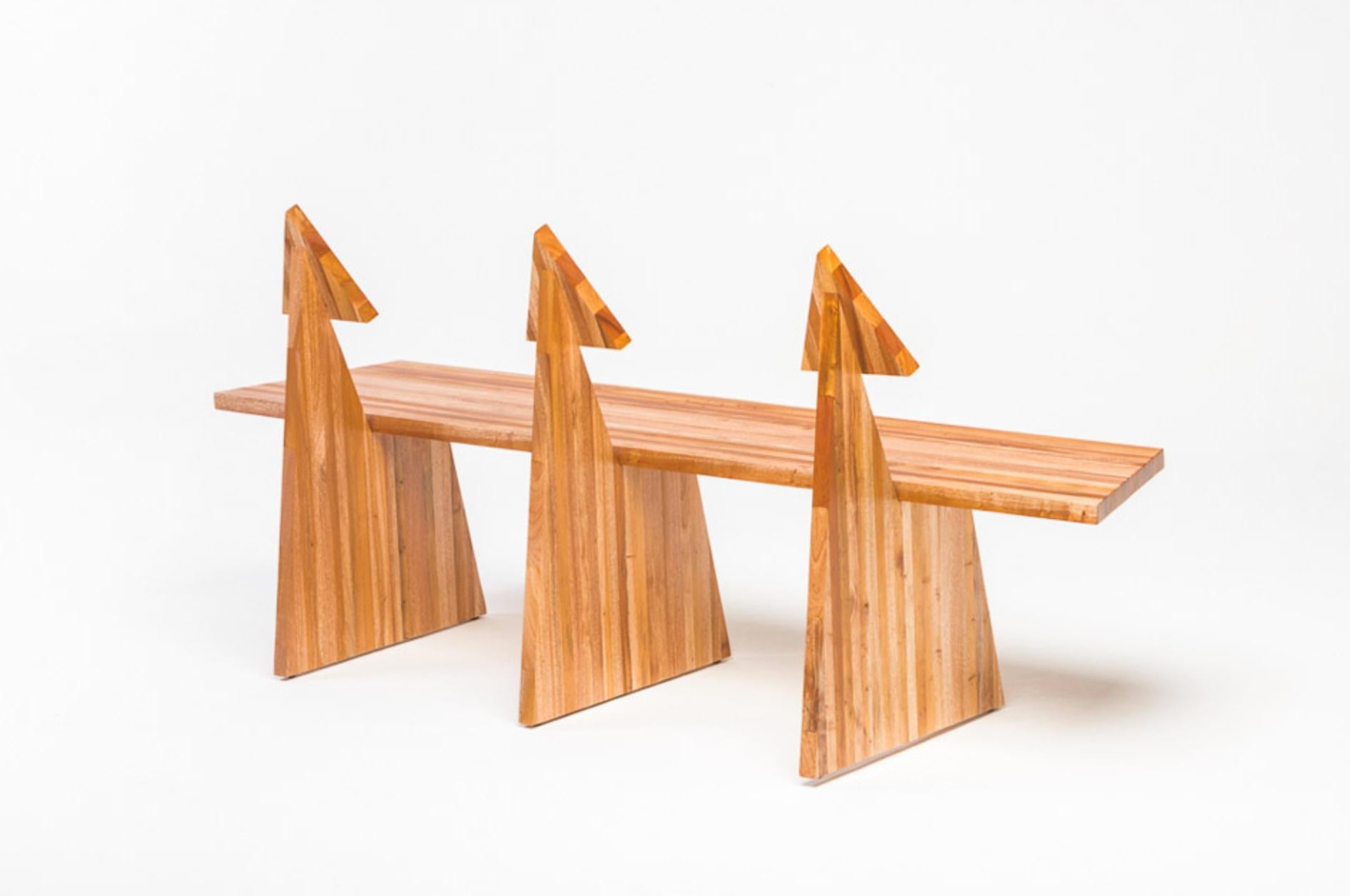 Designed by Juliana Lima Vasconcellos in 2018, the trio bench in made in solid African mahogany wood panels. This bench has a contemporary and simple image, inspired by pure geometric shapes and furniture of pre-modernist architects. The