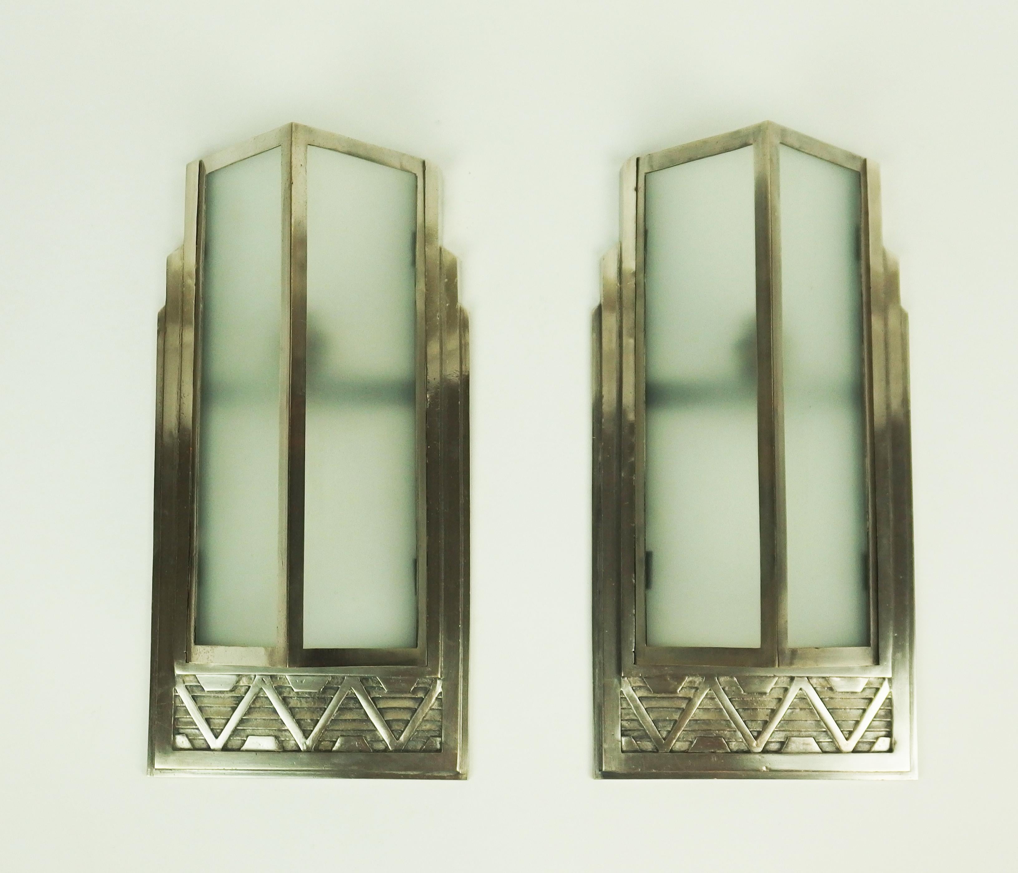 Pair of Art Deco silvered bronze sconces by Georges -Marius BorettiA pair of modernist Art Deco sconces with geometrical patterns in silvered bronze and a silvered brass structure holding sand blasted glass sheets.They are signed G M