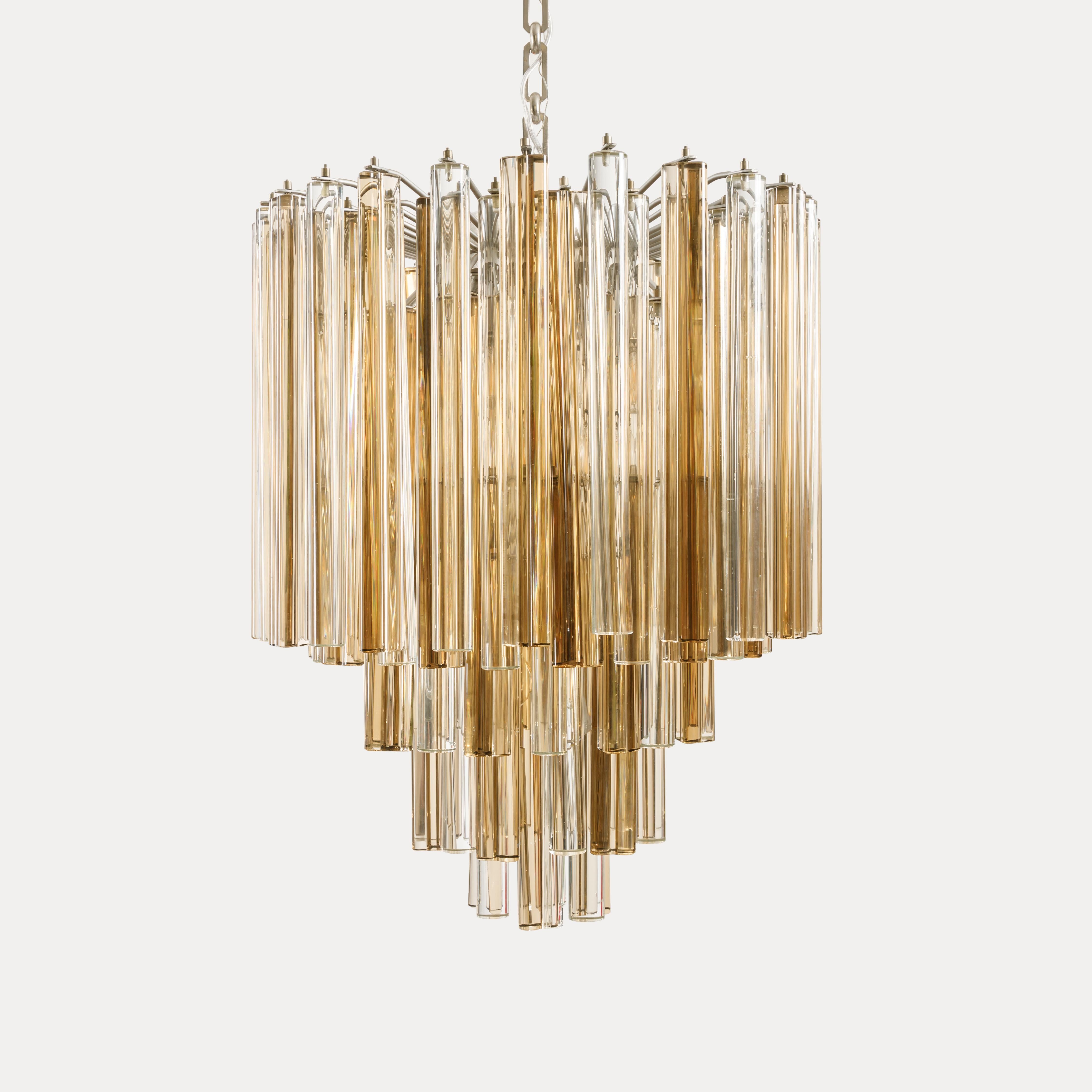 Exquisite Italian original 1960s Venini five-tiered chandelier from the 'Trilobo' series with 85 alternating crystal elements of amber and clear color in different sizes and suspended from a metal structure and canopy.  The blown glass from the
