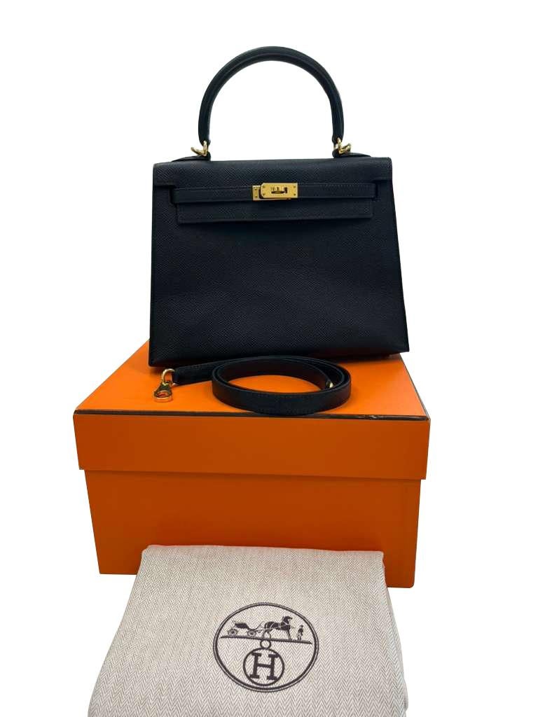 Hermès Kelly 25 Epsom noir avec quincaillerie dorée. Ce Kelly 25 Sellier de couleur noire attire tous les regards et s'accorde aussi bien avec un jean qu'avec une tenue de soirée. Super chic et très élégant avec des robes et des talons hauts. Inclus