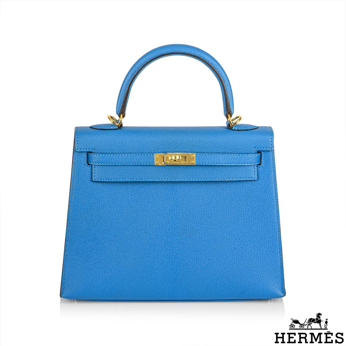A gorgeous Hermès Kelly 25cm Bleu Zanzibar Handbag. The exterior of this Kelly features a vivid Bleu Zanzibar Chevre Mysore leather with tonal stitching. It features gold tone hardware with front toggle closure, a rolled top handle with a detachable