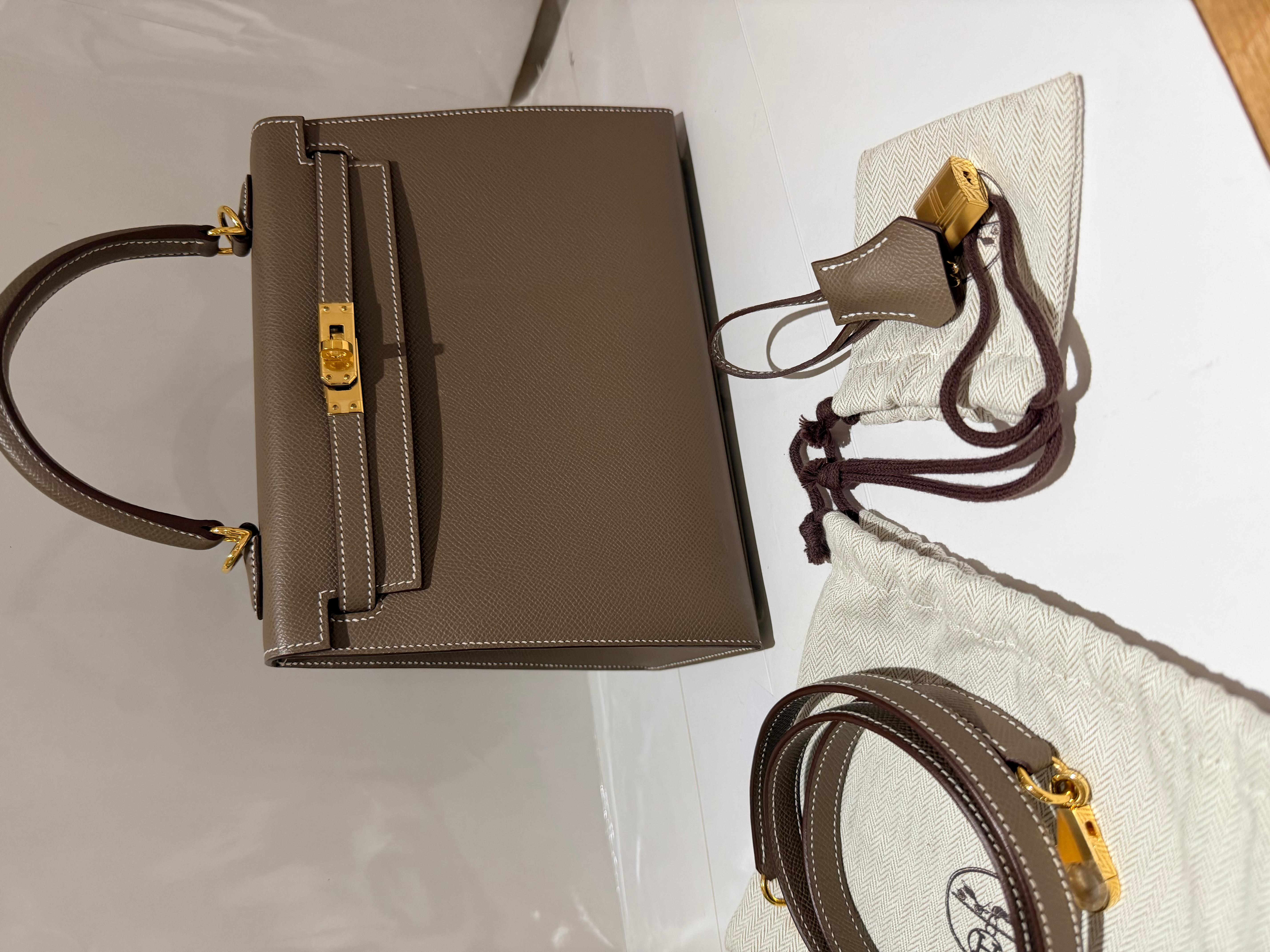 Sac Hermes Kelly 25 en couleur Etoupe, cuir d'epsom et métal doré. Ce Kelly 25 est un sellier, qui présente des coutures extérieures pour un aspect plus structuré.  C'est l'une des combinaisons de taille et de couleur les plus demandées ! Il