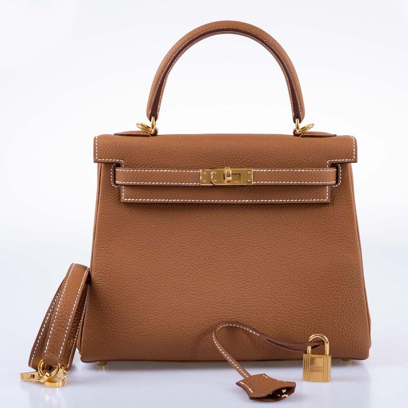 Hermès Kelly 25 Retourne Gold Togo Gold Hardware

The Gold Togo leather Hermès Kelly Retourne 25 is a true masterpiece of craftsmanship and style. Boasting a sleek and sophisticated design, this bag is crafted from the finest Togo leather, and