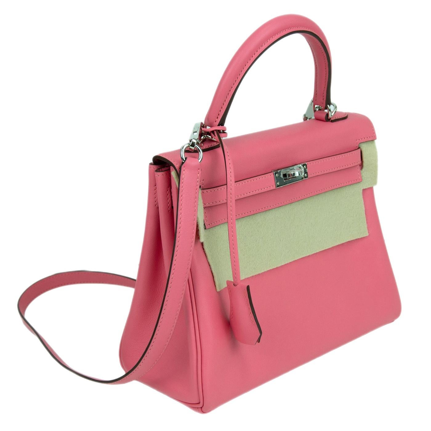 This Kelly, in the Retourne style, is in Pink Azalee swift leather with palladium hardware and has tonal stitching, two straps with front toggle closure, clochette with lock and two keys, single rolled handle and removable shoulder