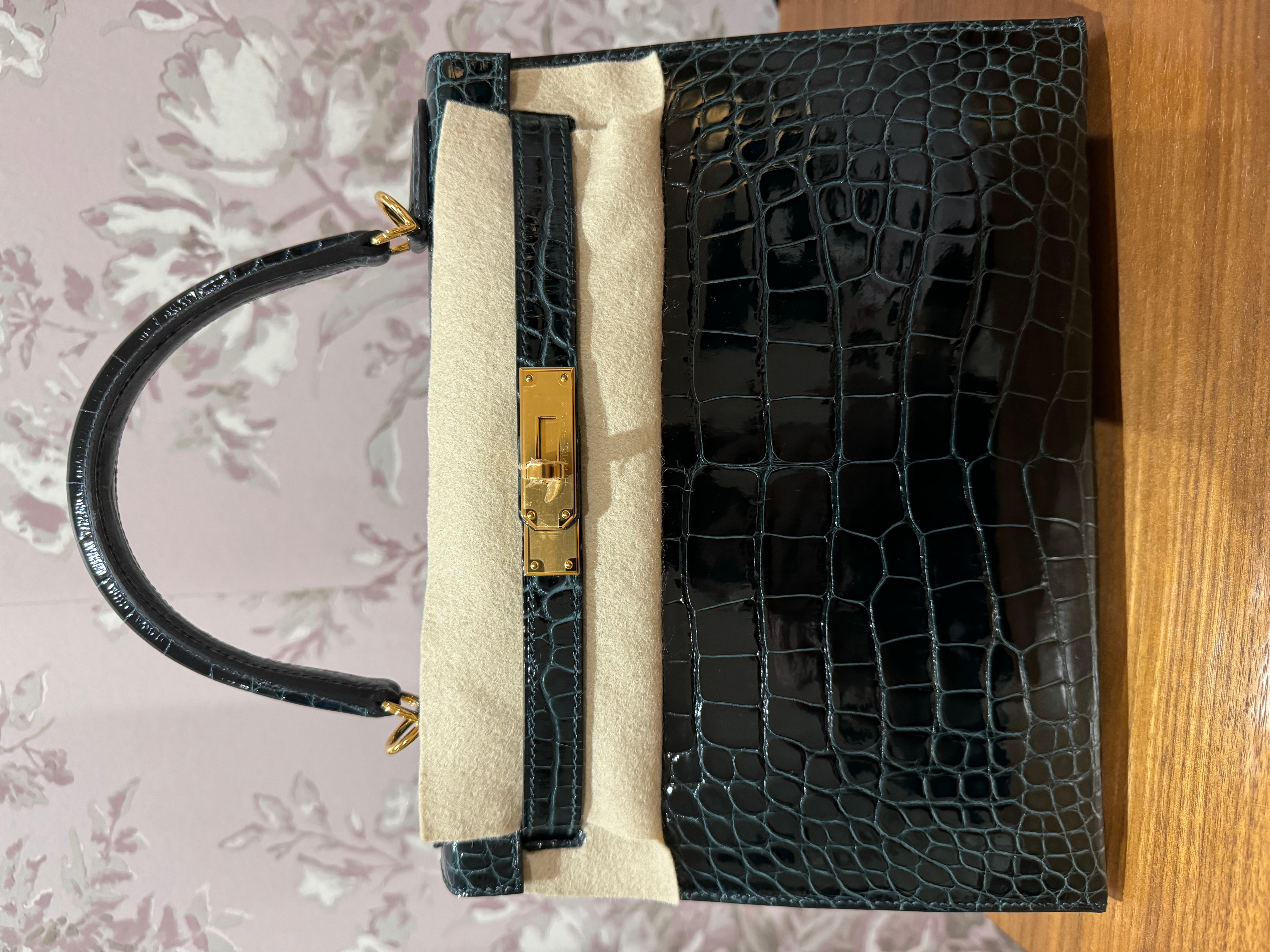 Hermes Kelly 28 Shiny Alligator in Vert Cypres colour and gold hardware. This bag is a statement piece; creates a classic and sophisticated look for a lady. The deep green colour has an emerald depth and a darker undertone for a timeless presence.