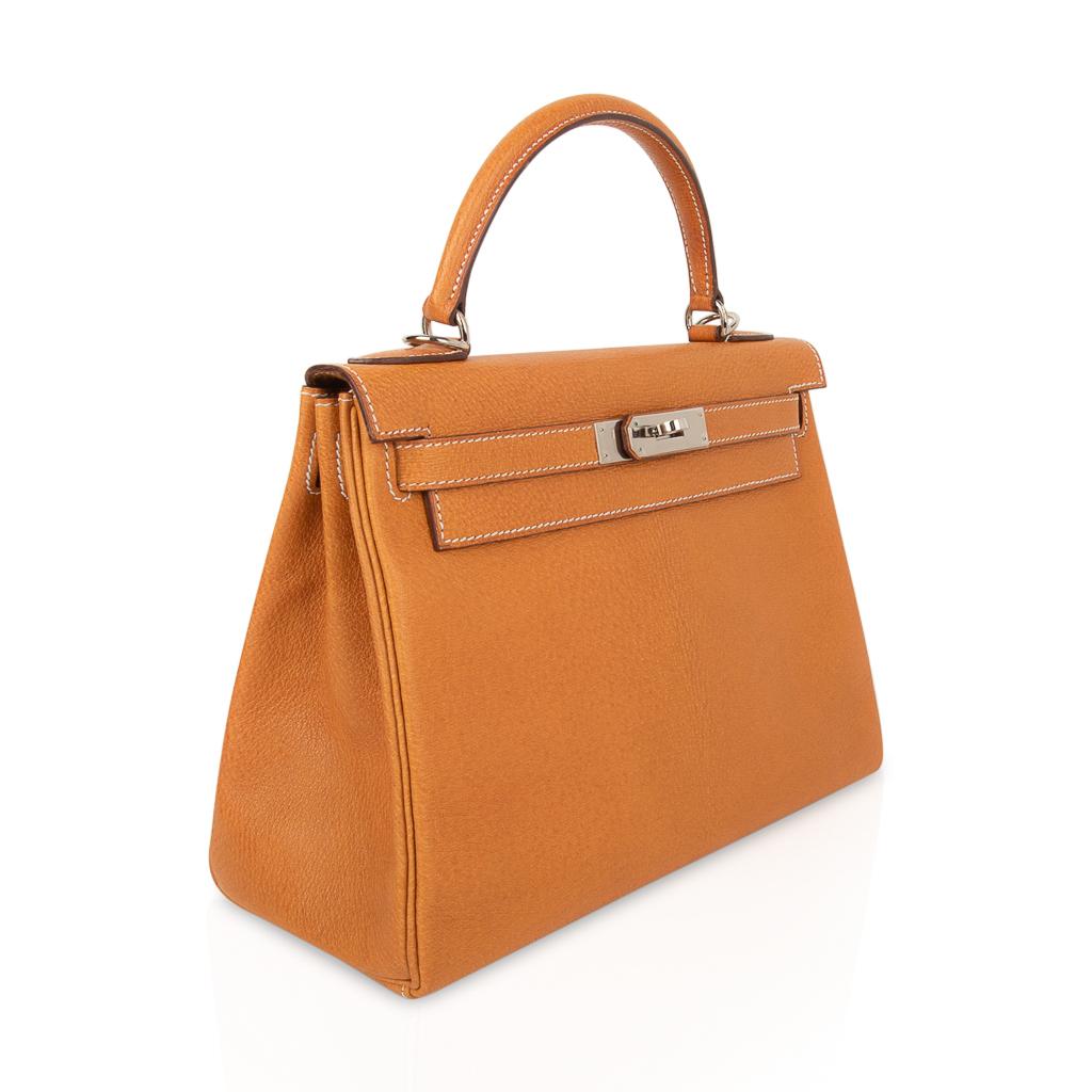 Mightychic offers an Hermes Kelly 28 bag features Gold in rare Peau Porc leather. 
Finished with palladium hardware and winter white top stitch.   
Comes with shoulder strap, sleepers, lock, keys and clochette. 
Plastic still on hardware.
The lock