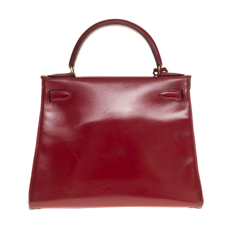 Splendid handbag Hermes Kelly 28 retourné in red calf leather (burgundy), gold plated metal hardware, simple handle in burgundy leather box, handle shoulder strap in burgundy box (not signed Hermès) allowing a hand or shoulder strap.

Closure by